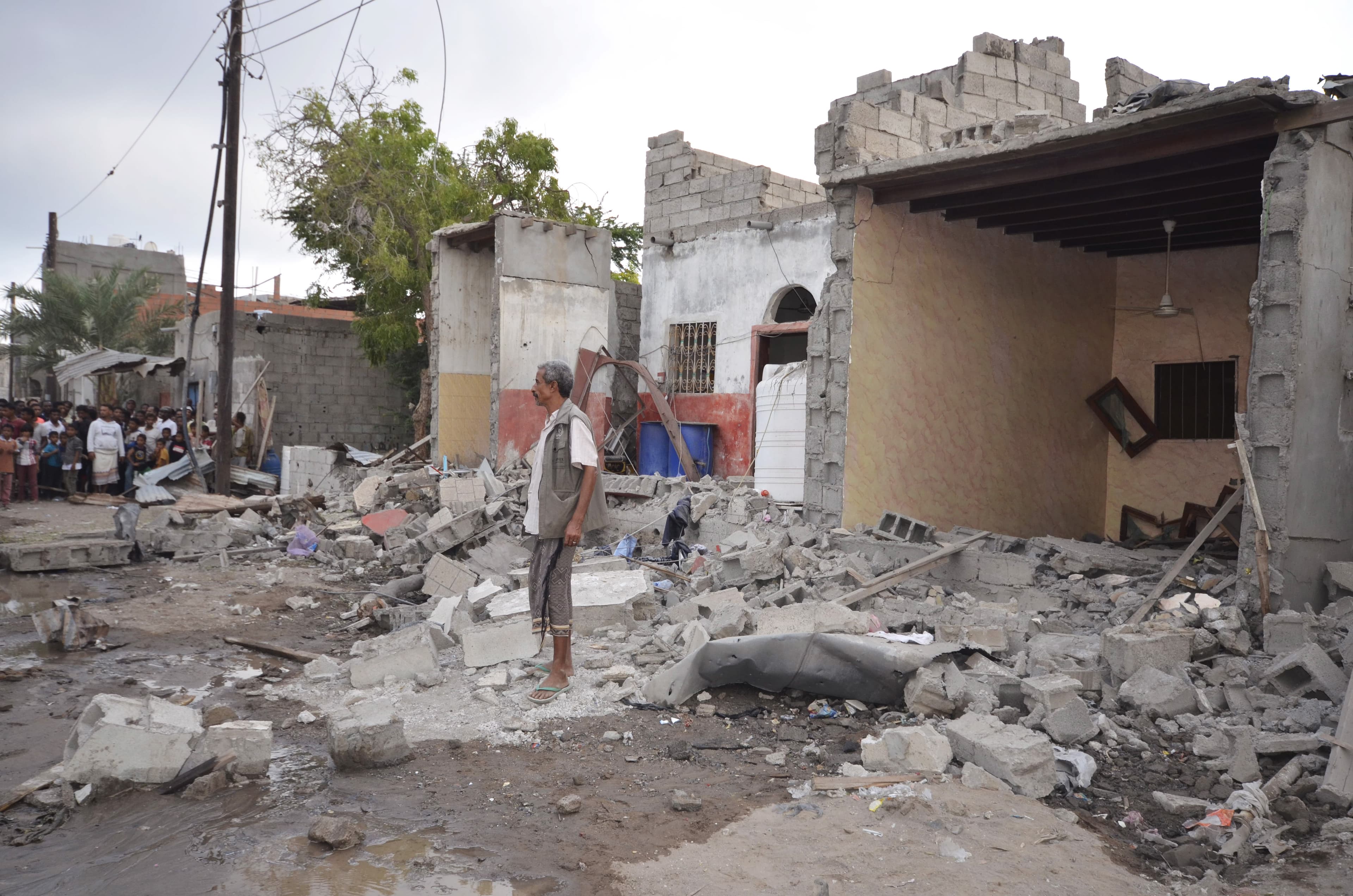 A man stands on the wreckage of a house destroyed by a Saudi-led air strike in Yemen's Red Sea port city of Houdieda