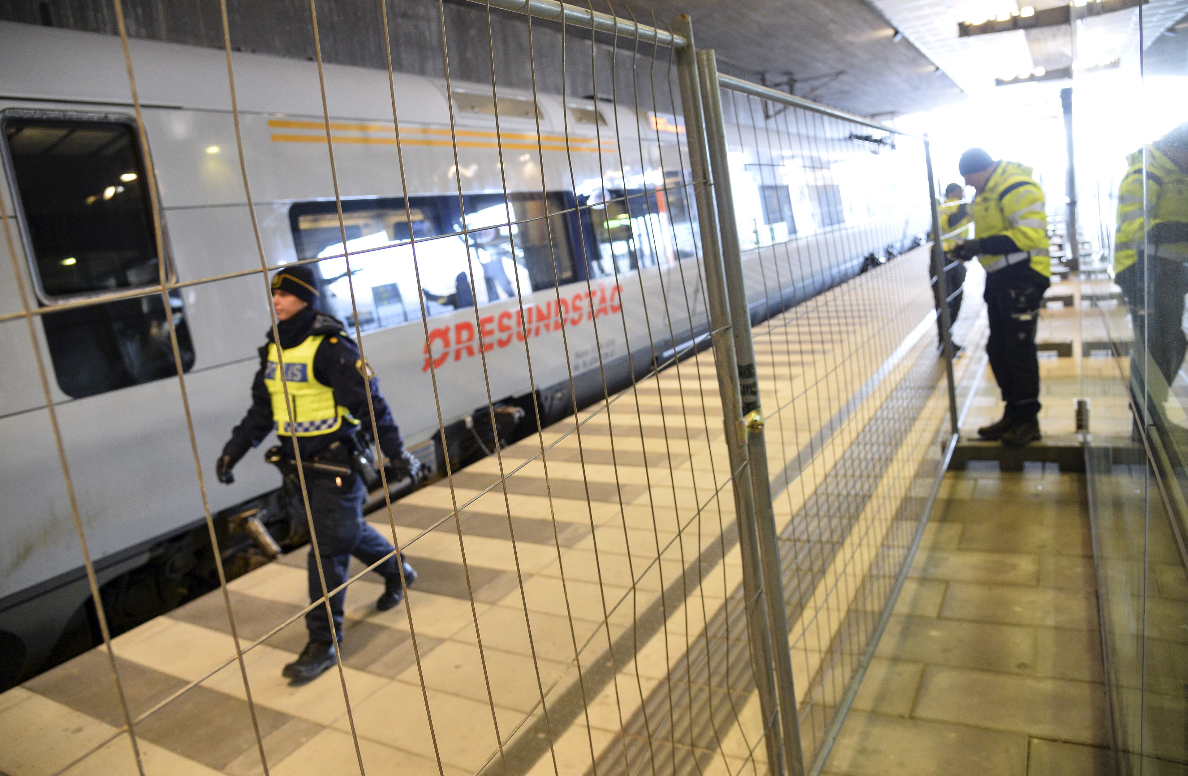 Swedish police officers erect a border control fence at Malmo on the Danish border