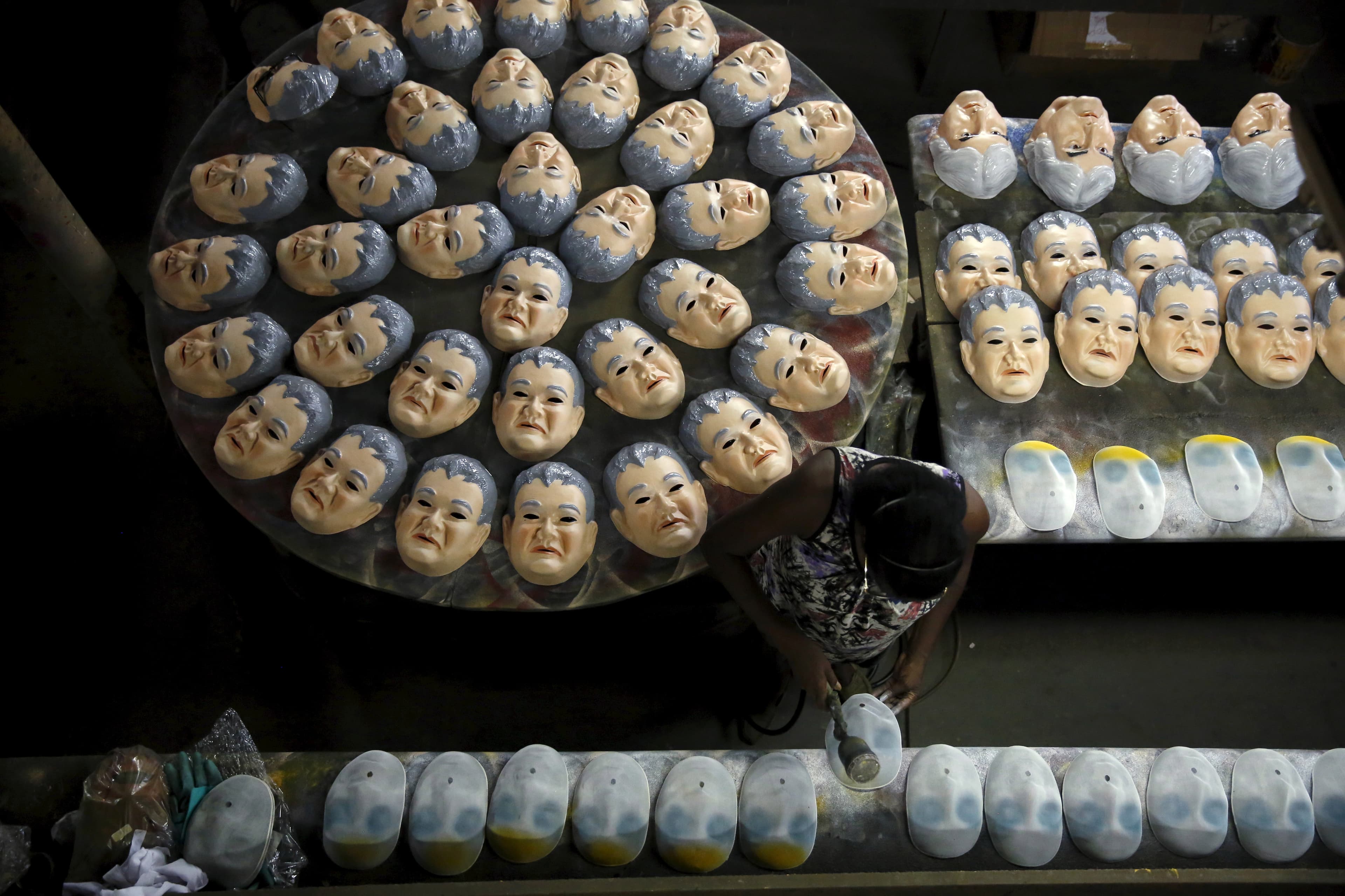A worker puts the final touches on a carnival mask bearing the likeness of federal police agent Newton Ishii, at a costume factory in the suburb of Rio de Janeiro, Brazil, January 11, 2016.