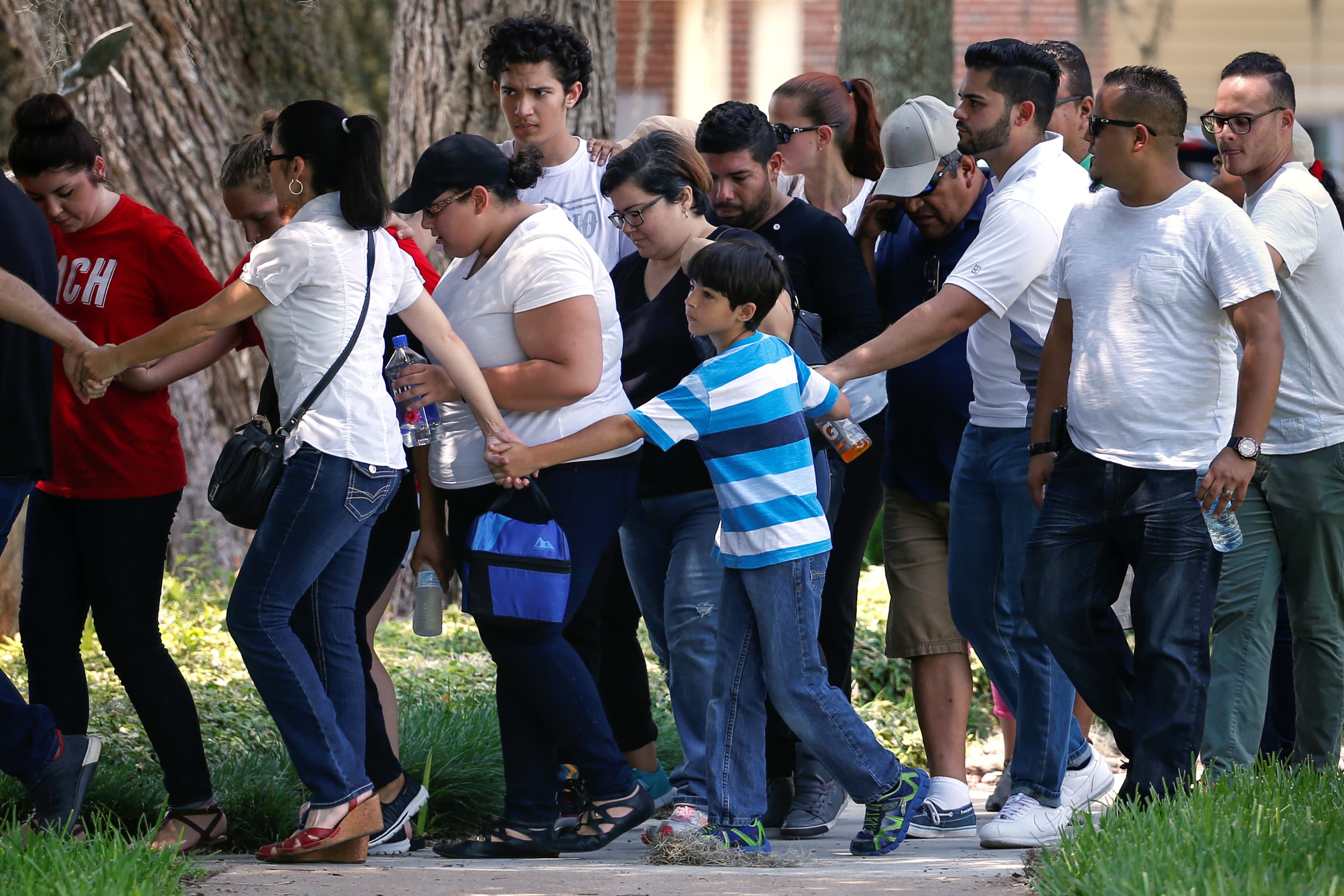 People join hands around group as they exit building