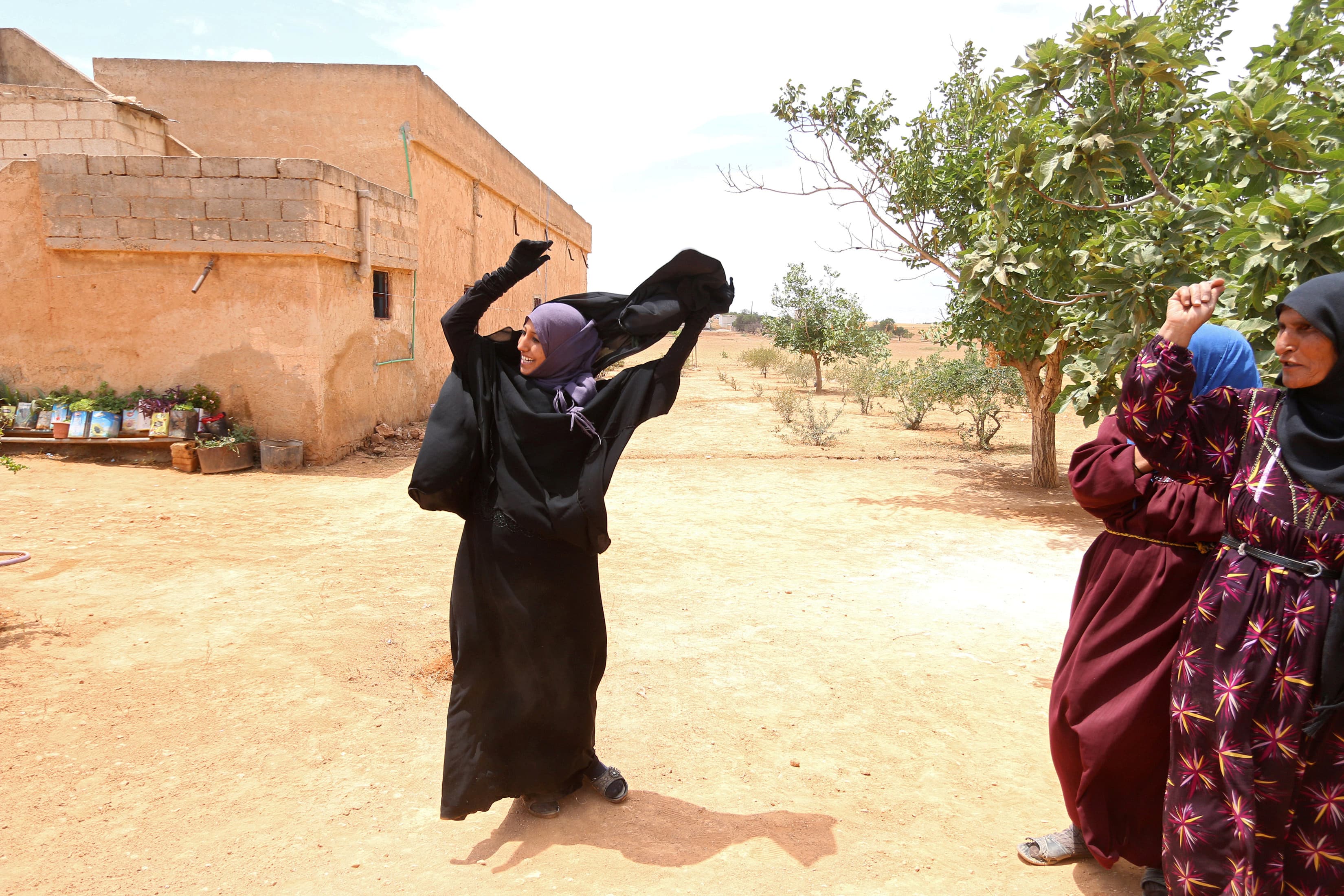 Souad Hamidi, 19, removes the niqab she said she had been forced to wear since 2014, after U.S.-backed Syria Democratic Forces took control of her village in northern Syria from Islamic State fighters on June 9, 2016.