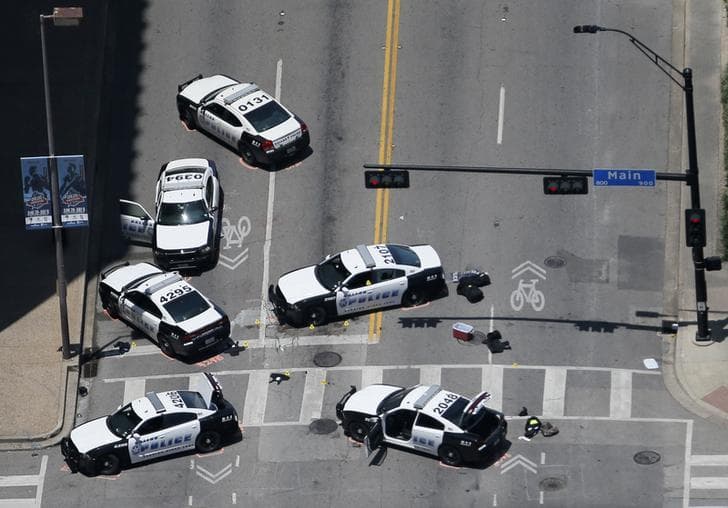 ​Police cars remain parked with the pavement marked by spray paint, in an aerial view of the crime scene of a shooting attack in downtown Dallas.