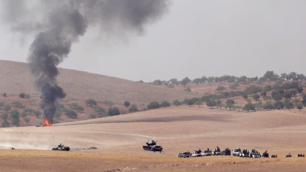 Turkish army tanks and Turkish-backed Syrian rebel fighters make their way in the Syrian border town of Jarablus on Aug. 24.