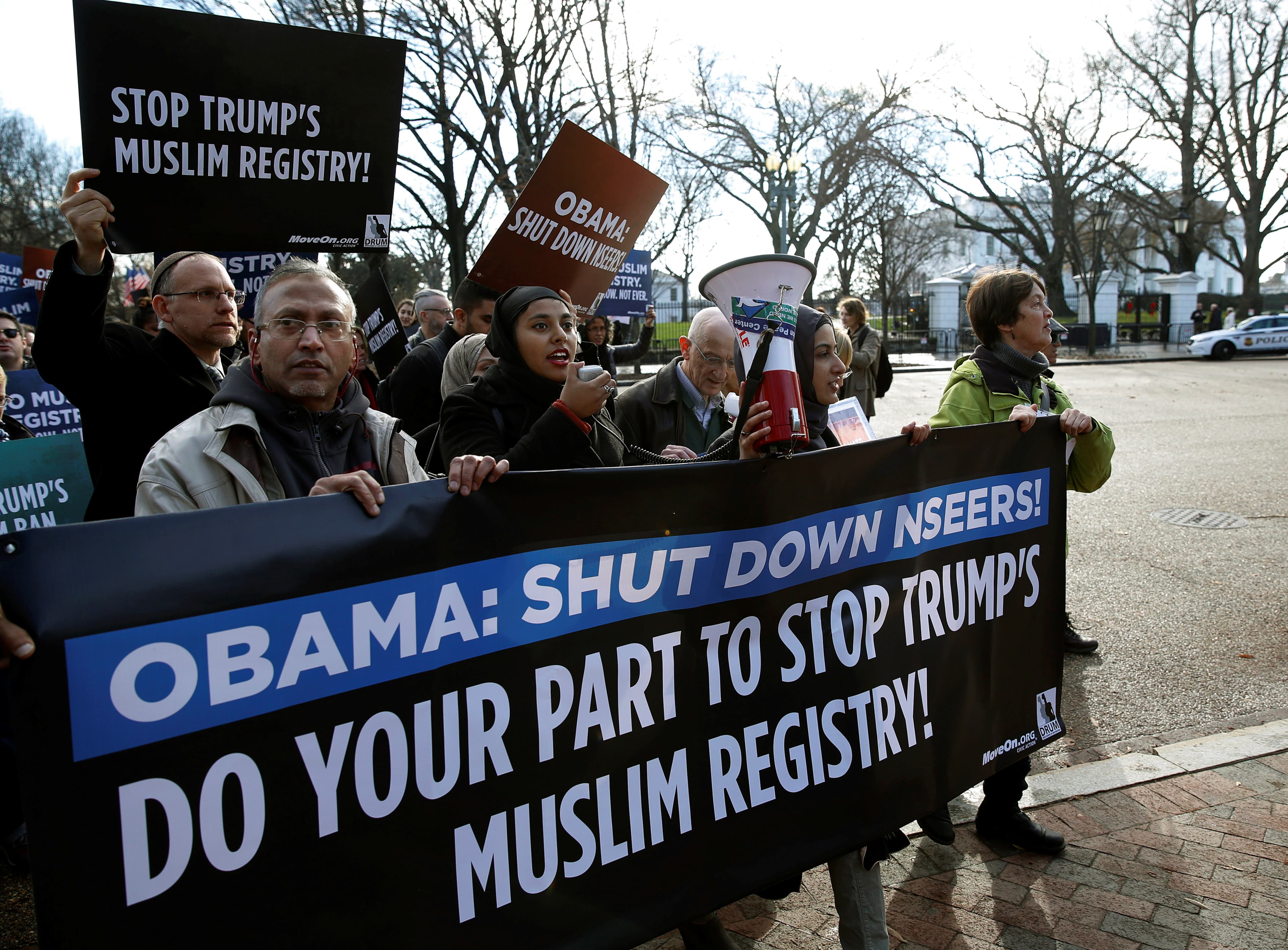 Protesters march with a sign that says "Obama: Shut down NSEERS"