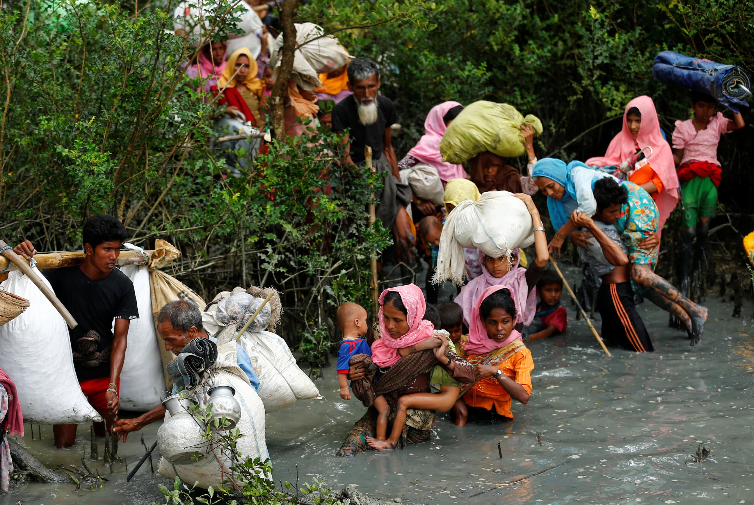 Rohingya refugees walk through water after crossing from Myanmar by boat through the Naf River in Teknaf, Bangladesh, on Sept. 7, 2017.