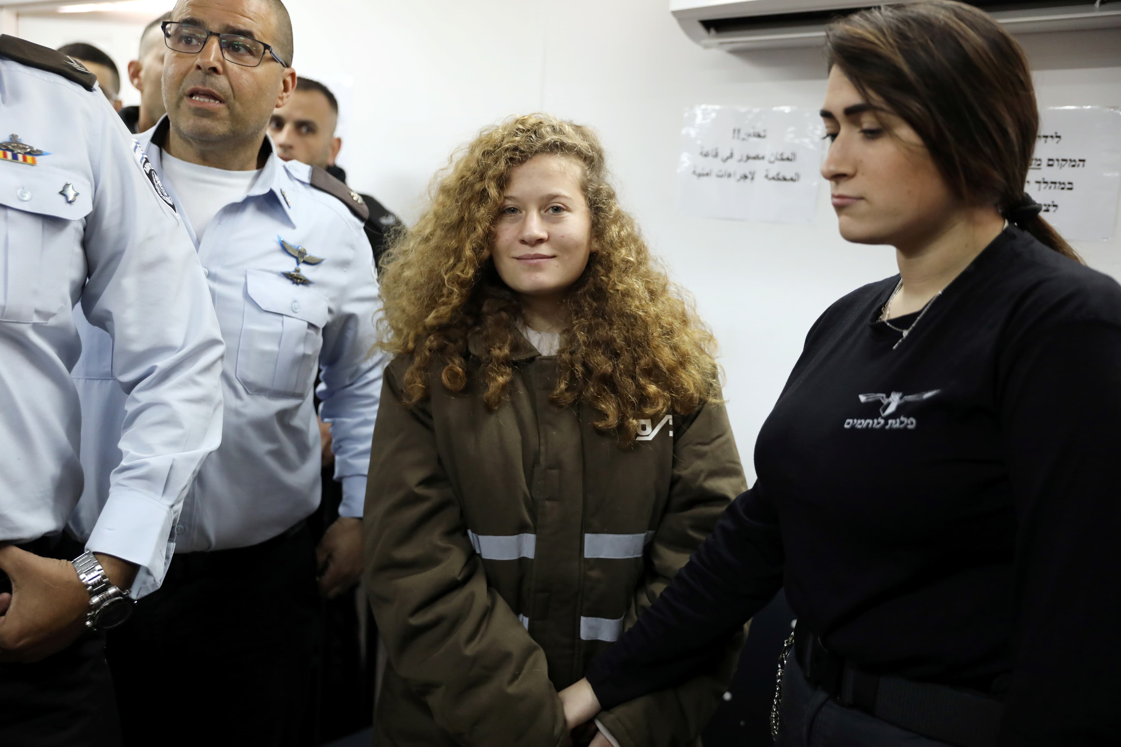 Palestinian teen Ahed Tamimi enters a military courtroom escorted by Israeli security personnel at Ofer Prison, near the West Bank city of Ramallah, Jan. 15, 2018.