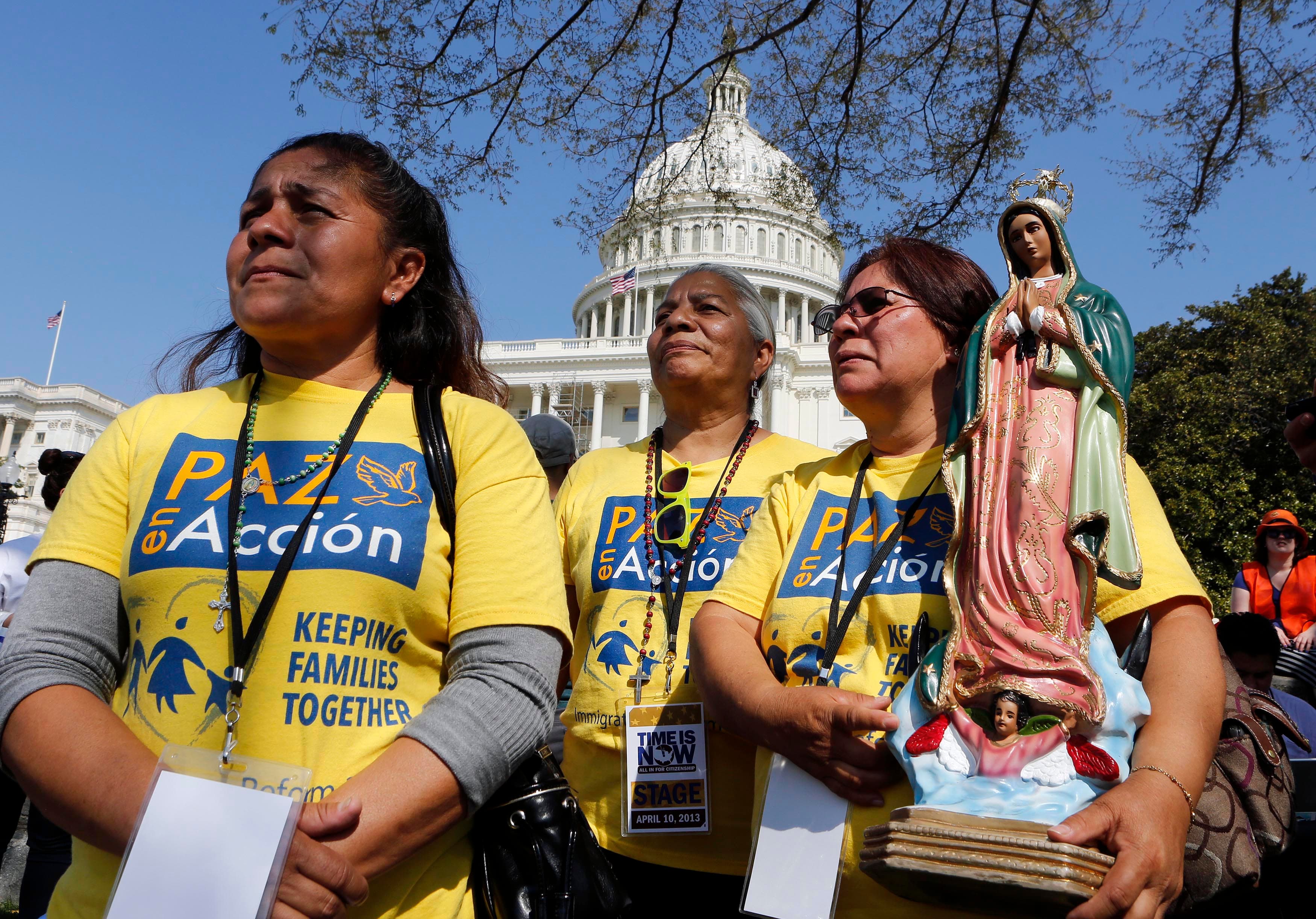 Three women protesting, with t-shirts and signs