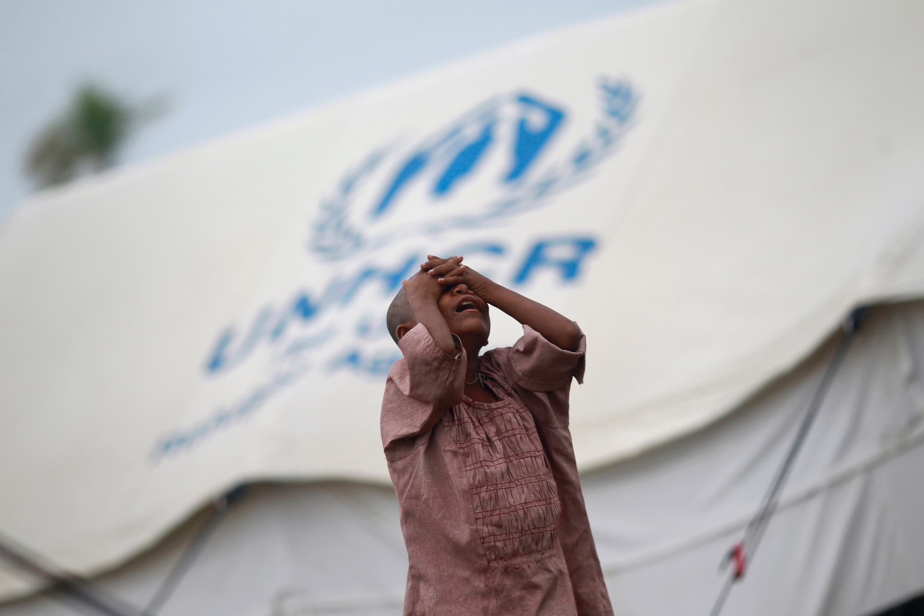 A girl from the Pauktaw township stands in front of her family's shelter in a Rohingya internally displaced persons camp