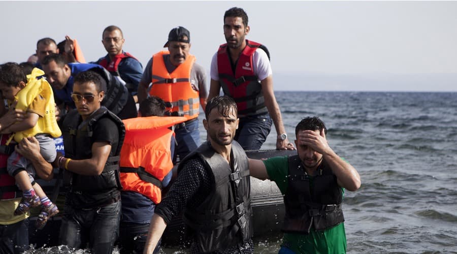 Syrian refugees arrive on a dinghy on the Greek island of Lesbos