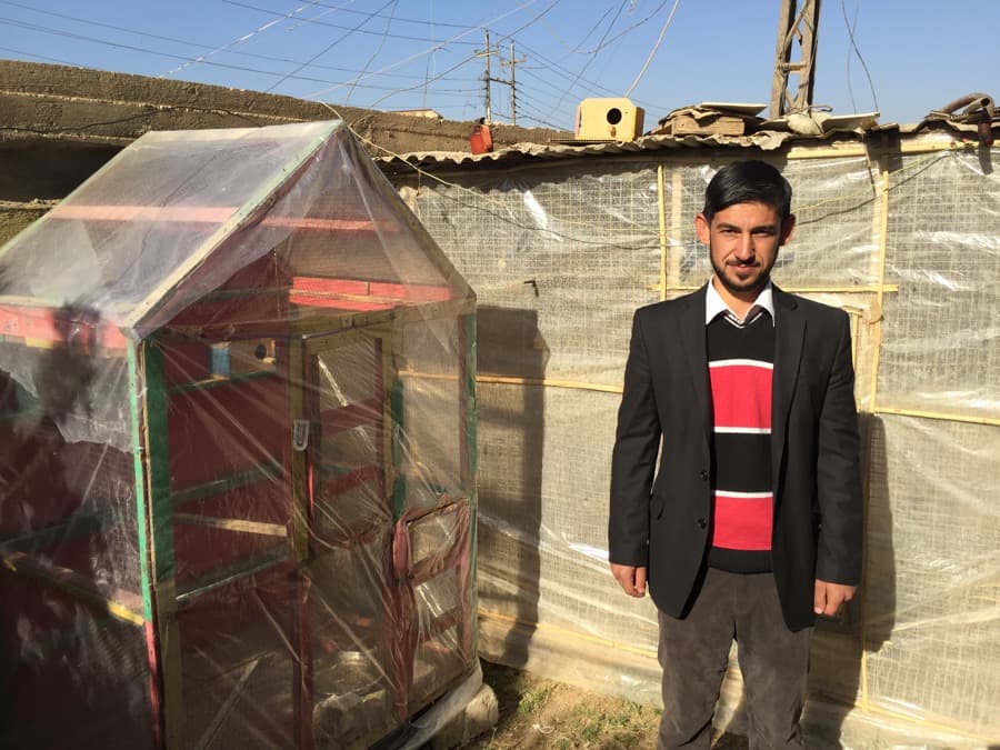 Riyad al-Jaboury, an Iraqi English teacher, with his birds in his yard in Hamam al-Alil, northern Iraq.