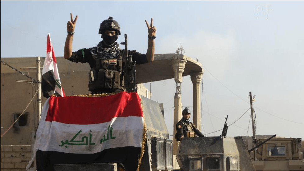 A member of the Iraqi security forces gestures at a government complex in the city of Ramadi, December 28, 2015.
