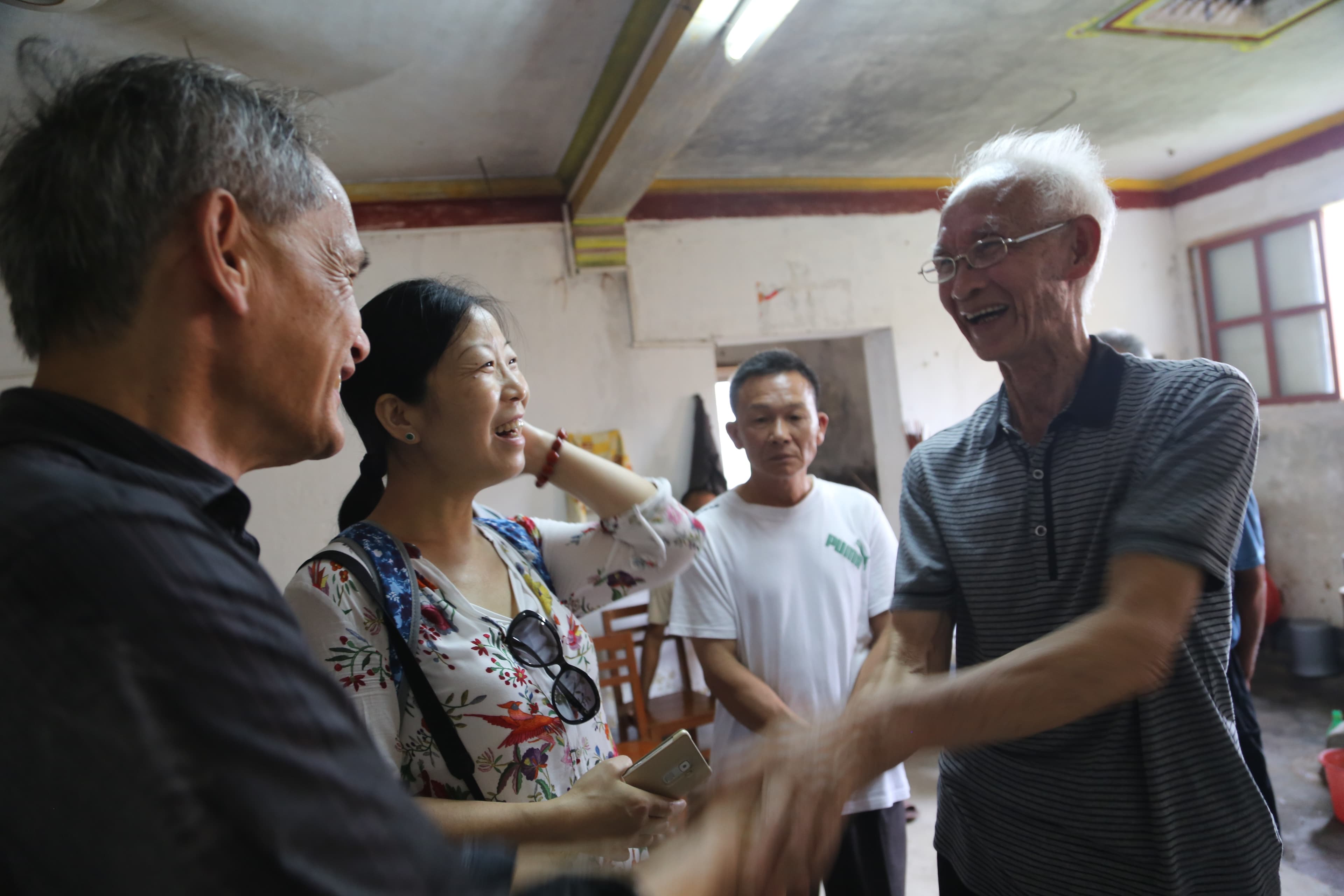 Two older men meet each other and shake hands.