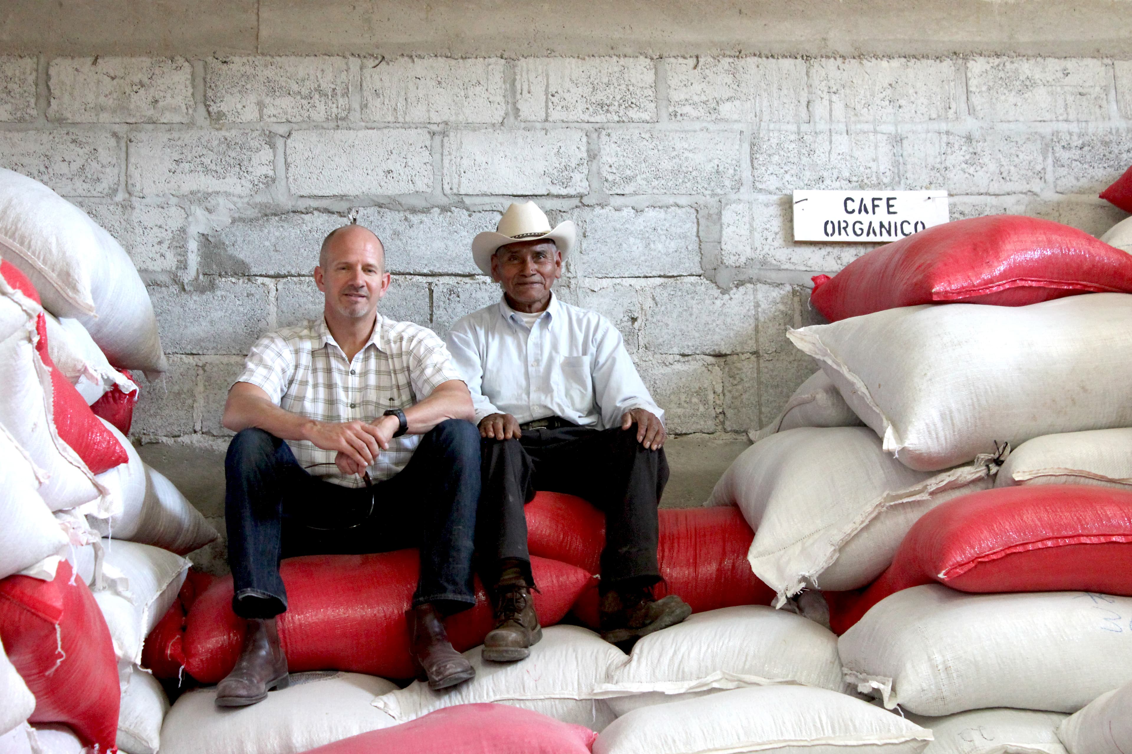 Root Capital founder Willy Foote visits with a coffee client, Jose Dominguez, in Marcala, Honduras, to survey the impact of la roya on coffee farms.