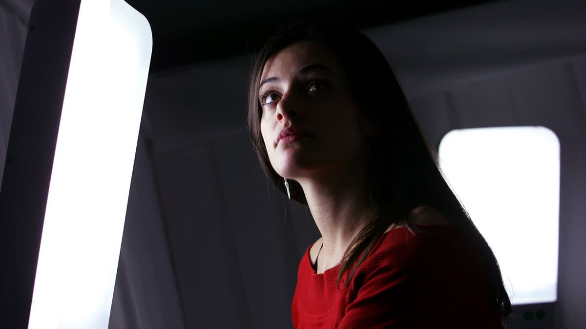 A visitor relaxes in the "Light Lounge," an ambient white space containing four specially designed light boxes where visitors can relax and have light therapy, in the Science Museum's Dana Centre in London. Light therapy is used to help beat the winter bl