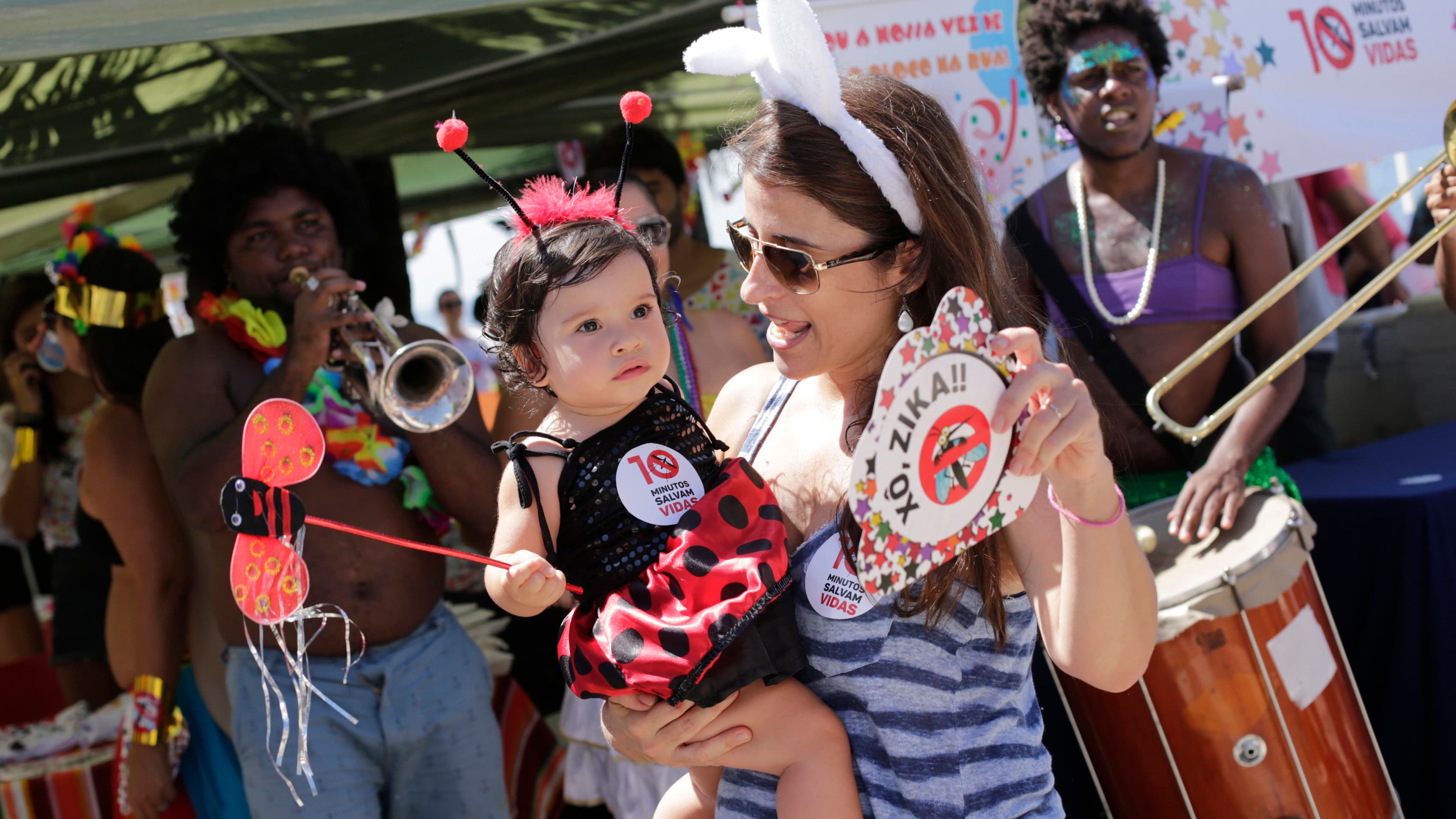A woman and child in costume dance during a street carnival at which health workers distributed kits with information about the Zika virus, on Ipanema beach in Rio de Janeiro, Brazil.