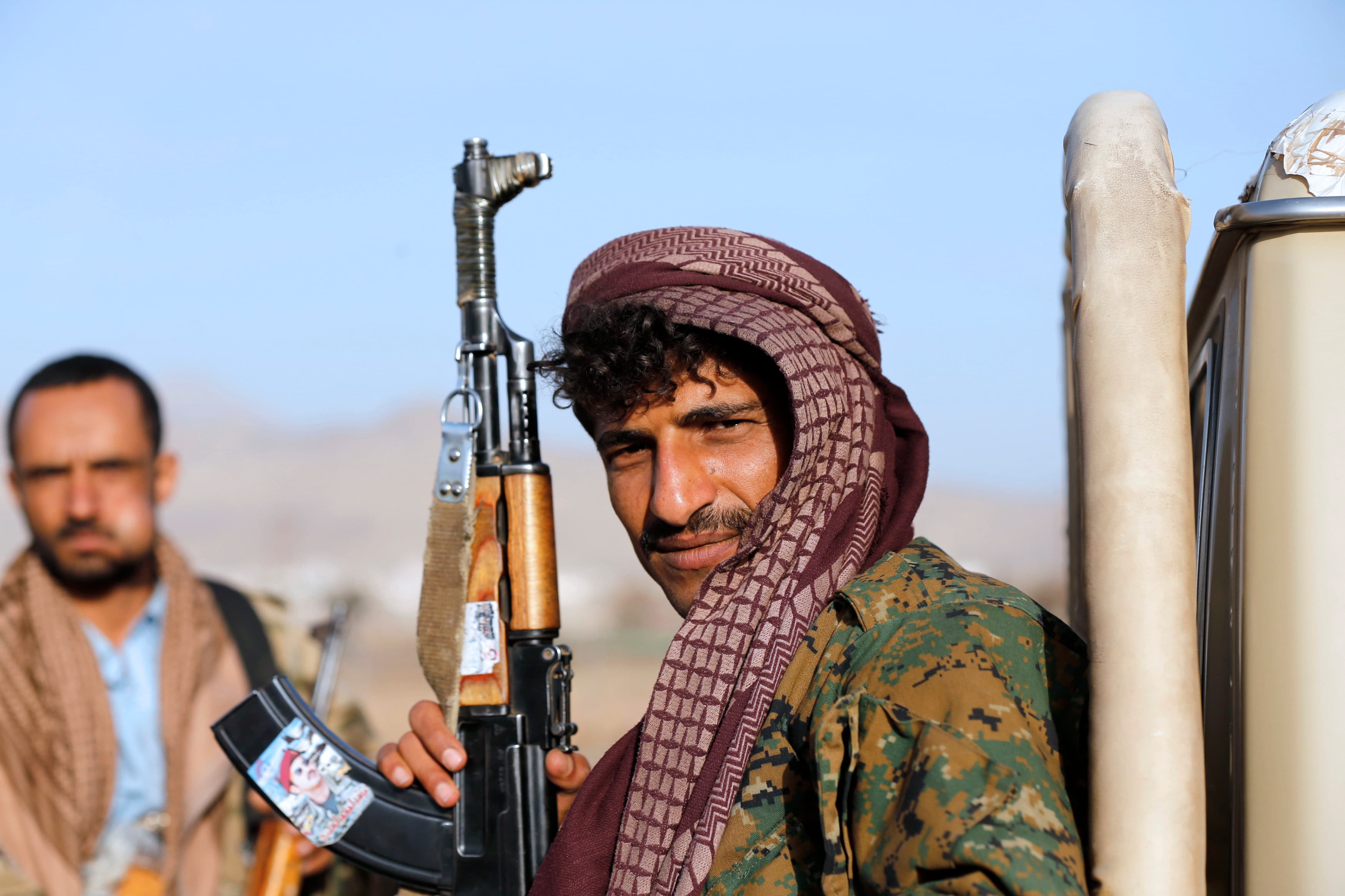 A Houthi fighter holds a rifle with a sticker portraying Ahmed Ali Abdulah Saleh, the eldest son of Yemen's former president Ali Abdullah Saleh, as he rides a truck near the presidential palace in Sanaa.  On Thursday, Houthi rebels welcomed proposed conce