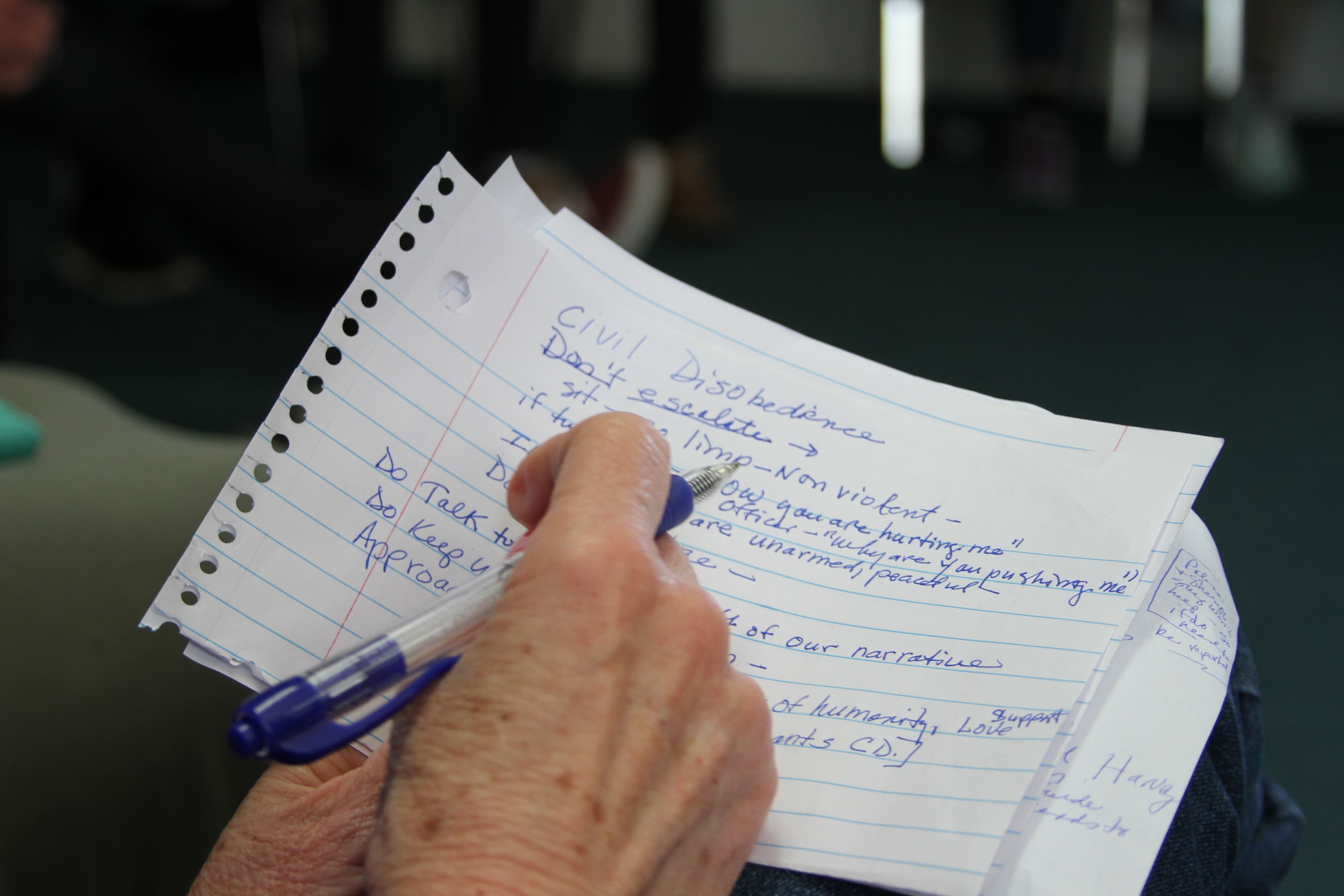 Hand holding pen taking notes that read "civil disobedience"