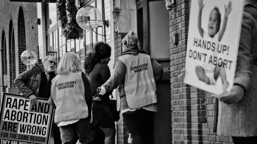 Escorts surround this patient outside of Metropolitan Medical Associates in Englewood, New Jersey.