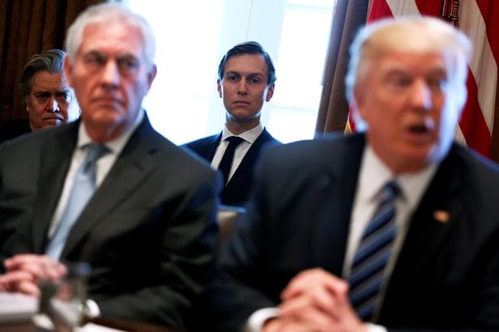 Secretary of State Rex Tillerson and President Donald Trump appear in a blurry photograph during a cabinet meeting. White House advisors Steve Bannon and Jared Kushner look on in the background.