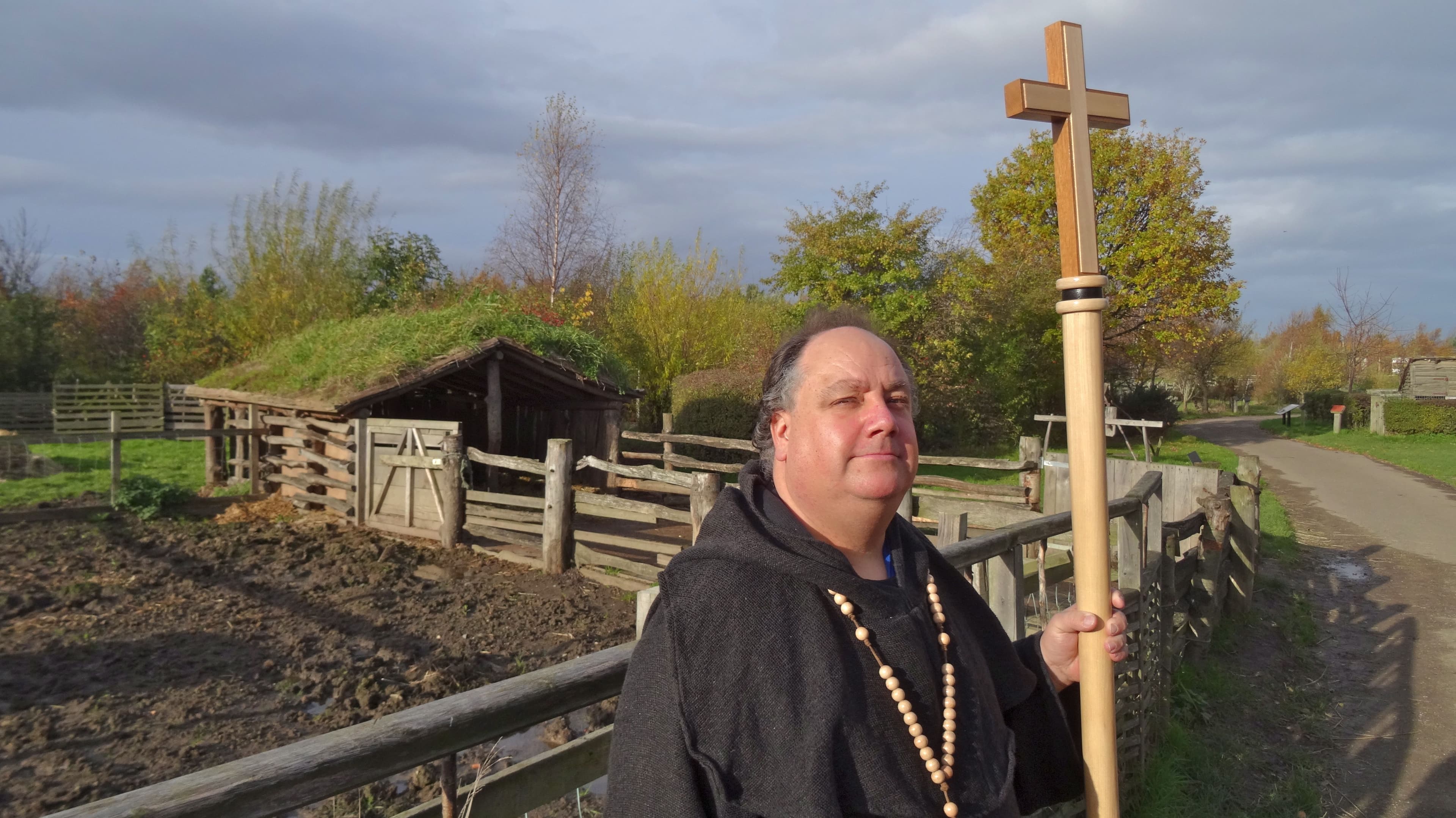 At Bede's World in Jarrow, Britain, a staff member dressed as a monk poses in front of a recreation of an Anglo-Saxon animal shelter.