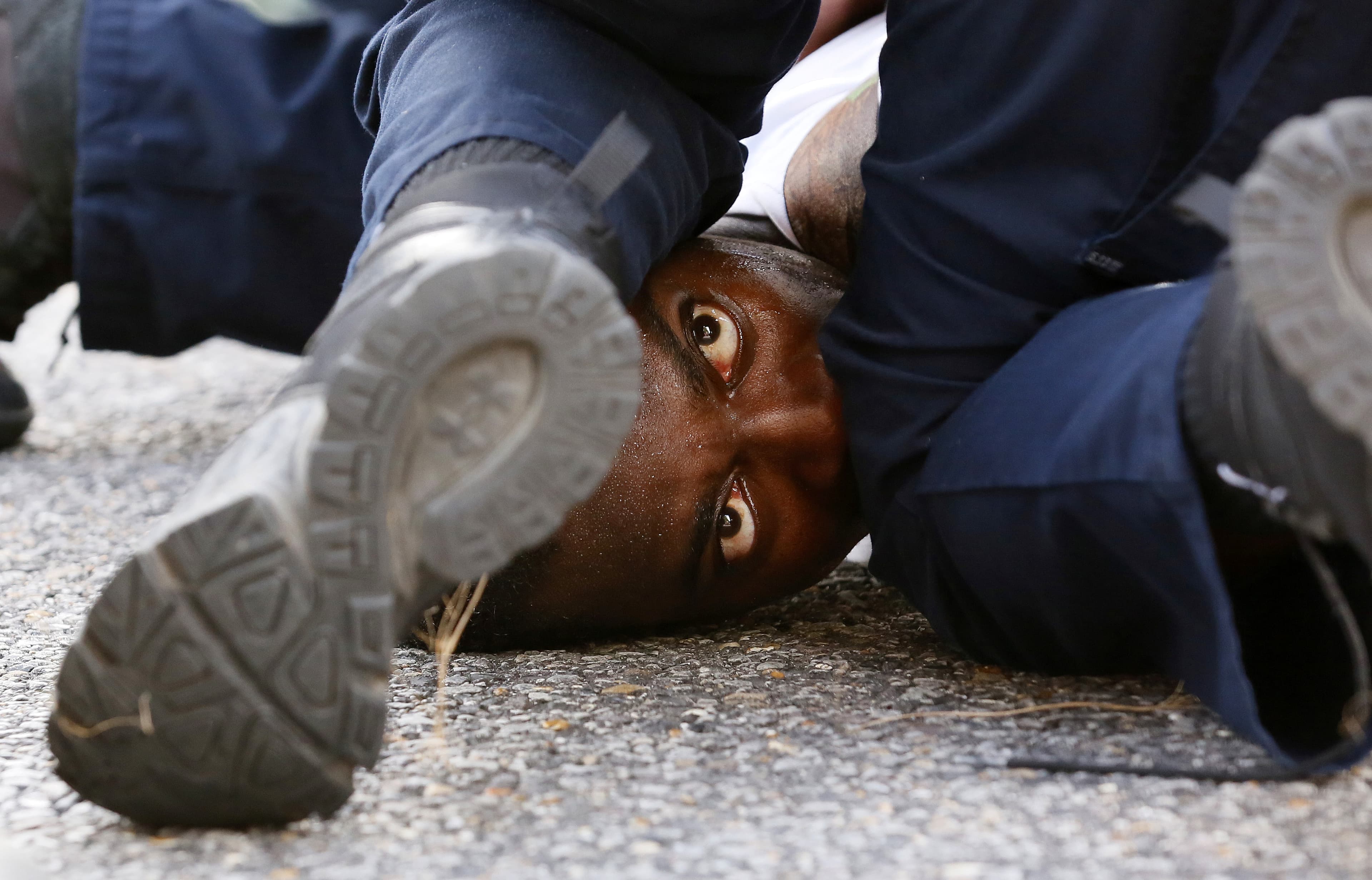A man protesting the shooting death of Alton Sterling is detained by law enforcement near the headquarters of the Baton Rouge Police Department in Baton Rouge, Louisiana, on July 9, 2016.