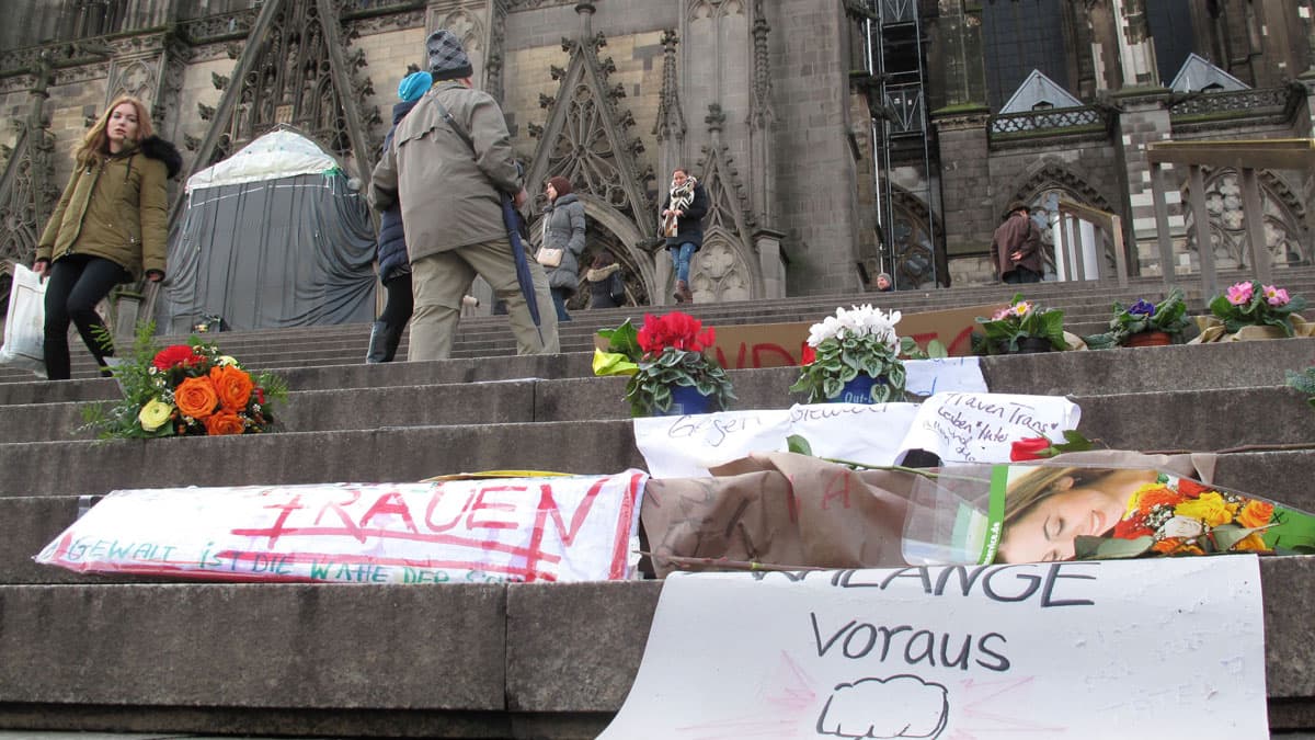 Flowers and handwritten signs for the sexual assault victims have been left on the steps of Cologne's Gothic cathedral. Hundreds of women reported being victimized in this area during a chaotic New Year's Eve.