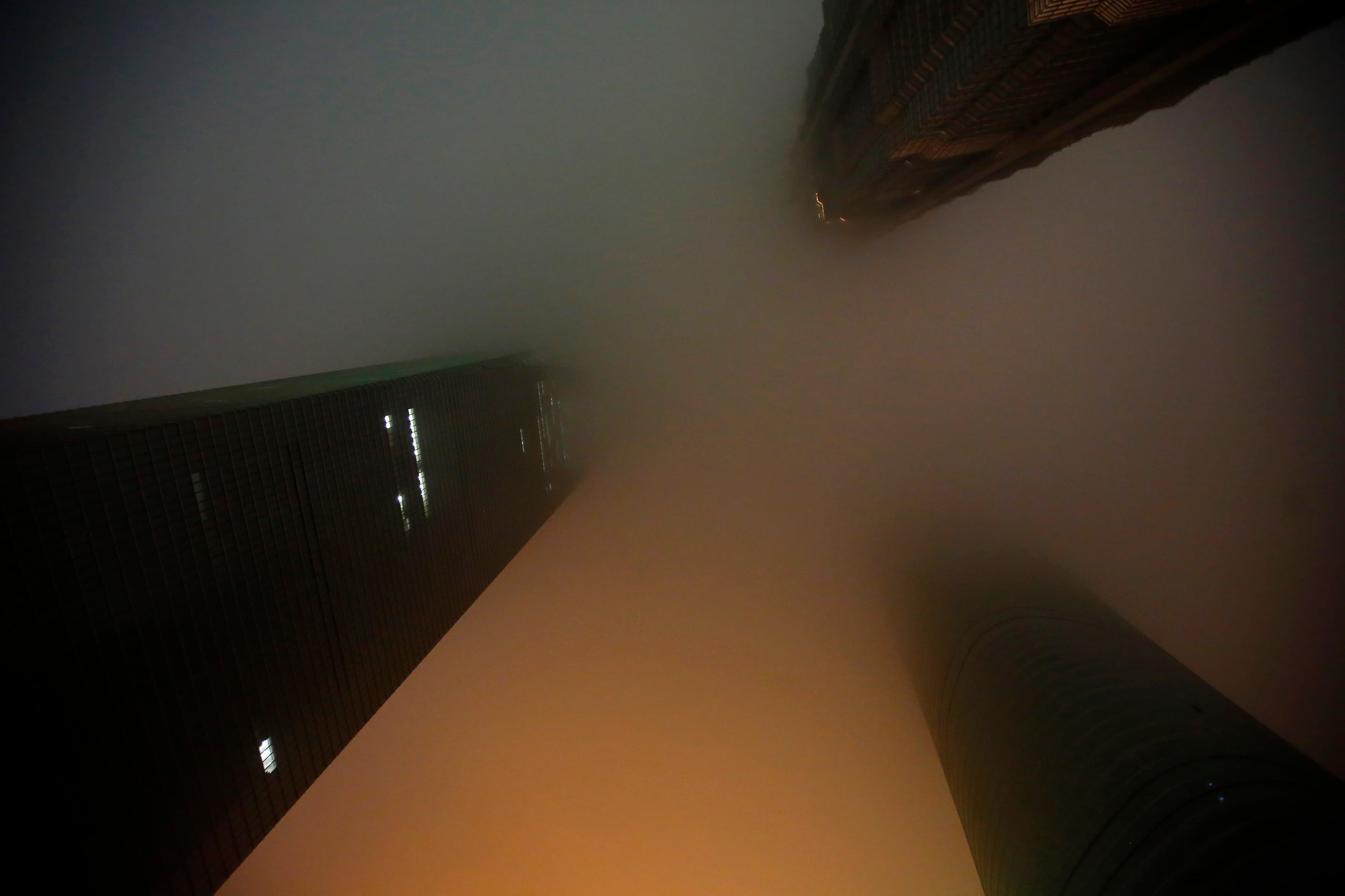 Shanghai's skyscrapers Shanghai World Financial Center, left, Shanghai Tower, right, and Jin Mao Tower are seen at the financial district of Pudong during Earth Hour in Shanghai March 29, 2014. The buildings were shrouded in pollution.