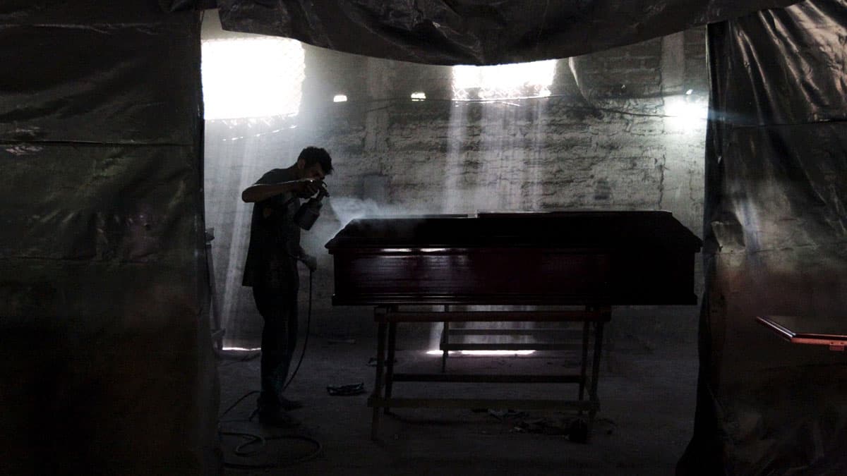 A worker paints a coffin at El Nuevo Renacer factory in Jucuapa, El Salvador.