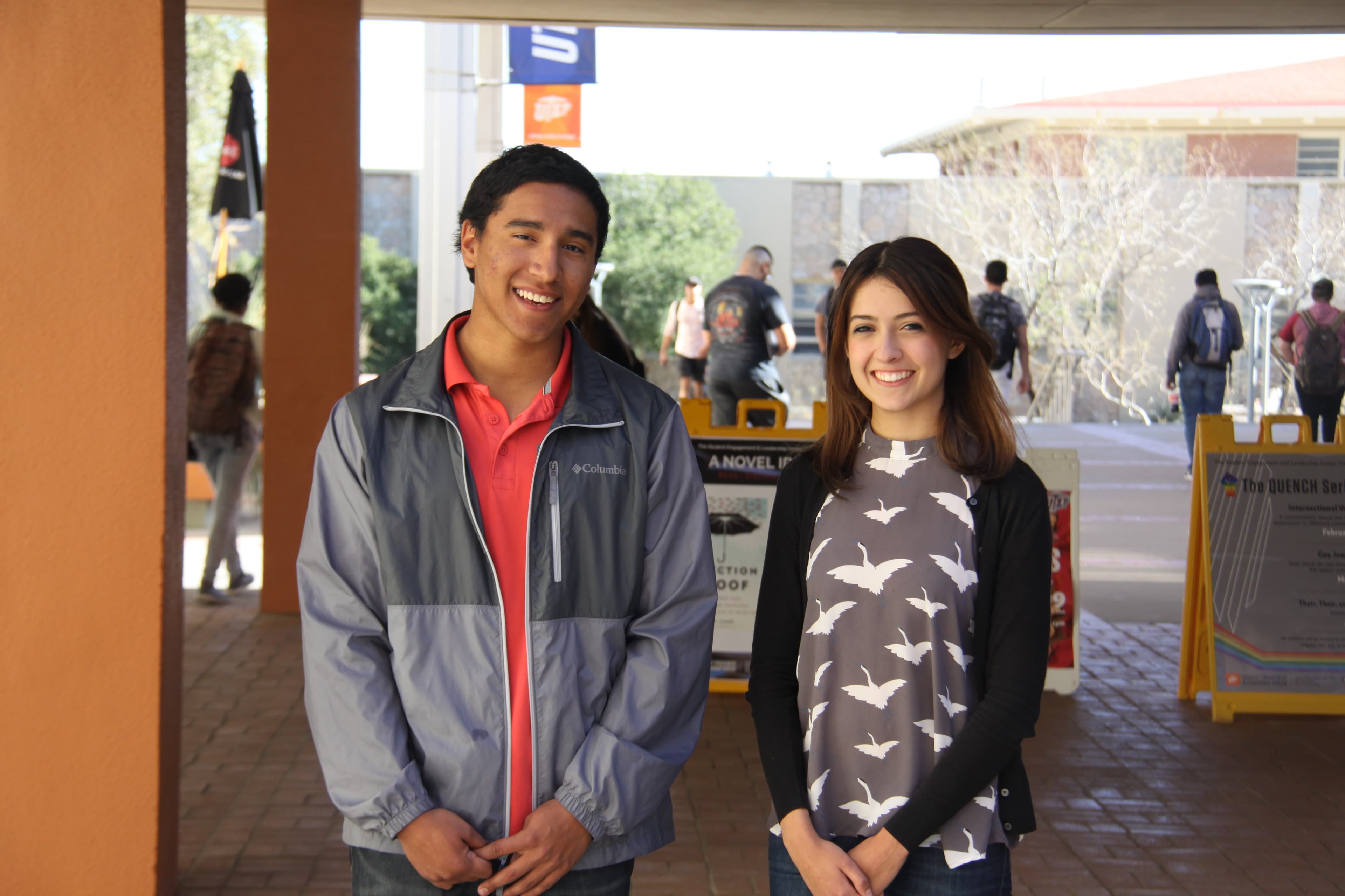 Two college students smile at the camera.