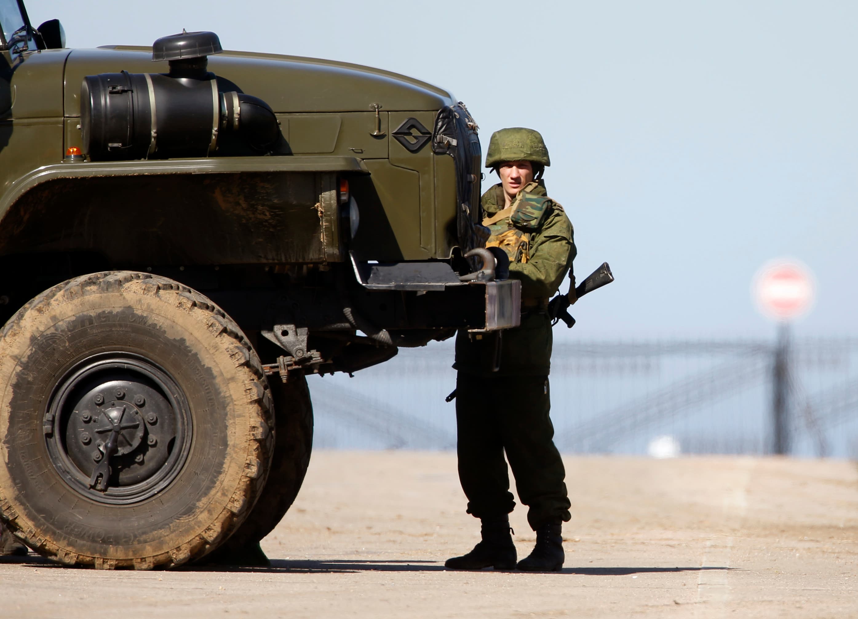 A military personnel member, believed to be a Russian serviceman, stands guard near a local airfield, near the territory of a Ukrainian military unit in the village of Lyubimovka, some 80 km (50 miles) southwest of Simferopol, Crimea's capital.