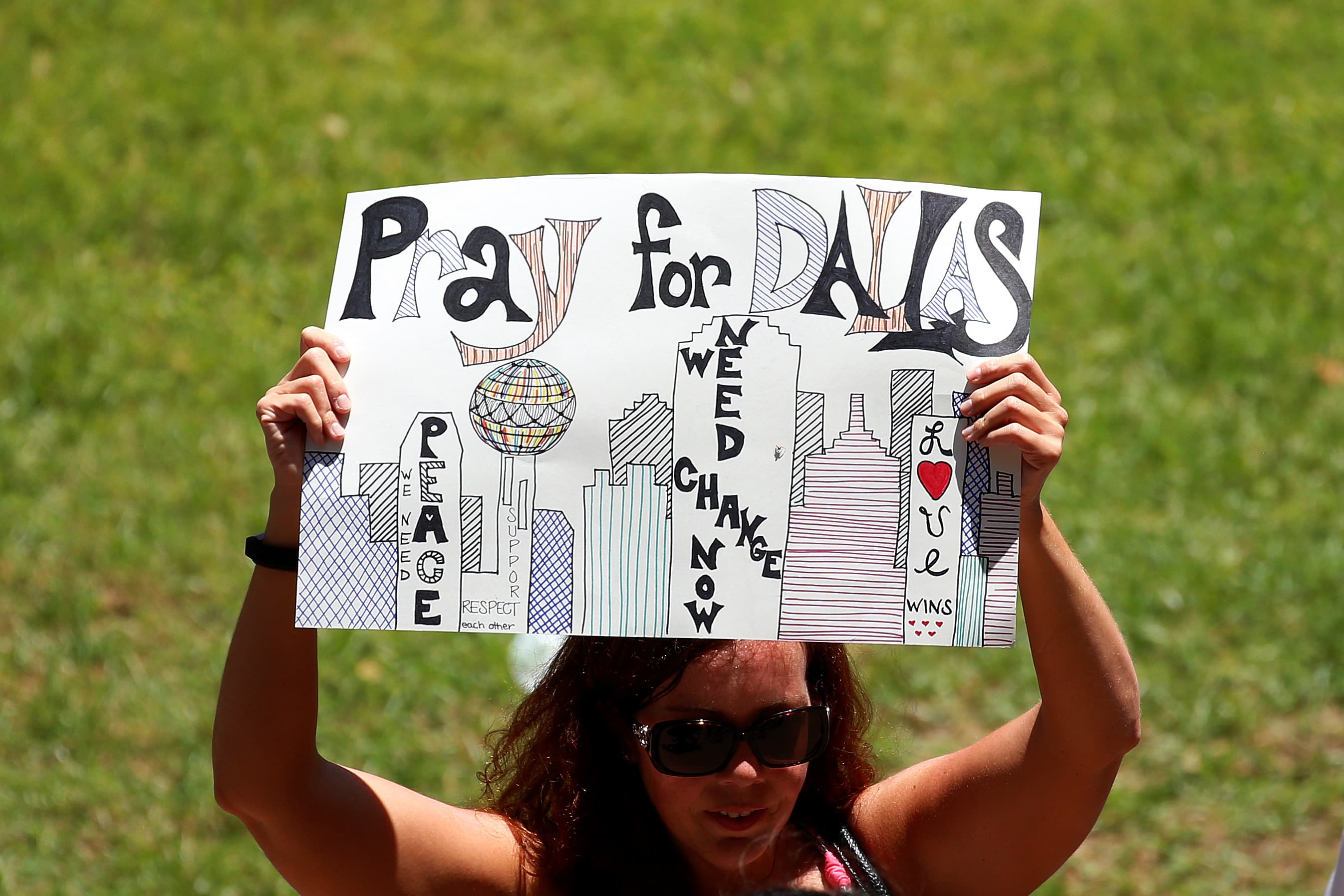 A woman holds up a sign of support during a prayer vigil