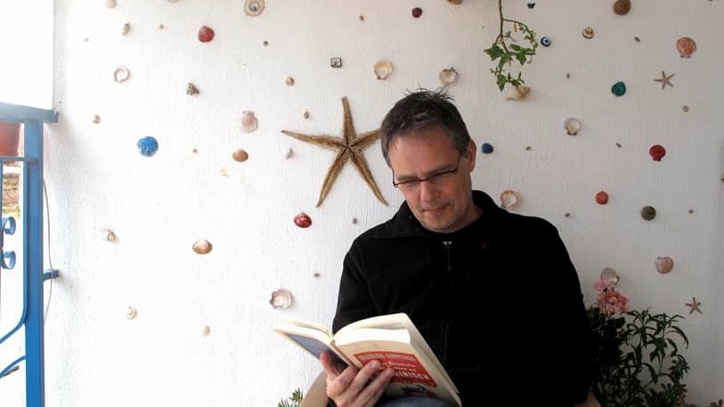 Dutch-born author of Lingo Gaston Dorren. Dorren is pictured here in Turkey reading the German translation of book originally written in English: A Short History of Tractors in Ukrainian by Marina Lewycka. Dorren's first language is Limburgish.