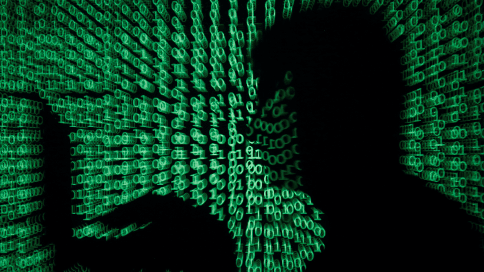 A man holds a laptop computer as cyber code is projected on him in this illustration.