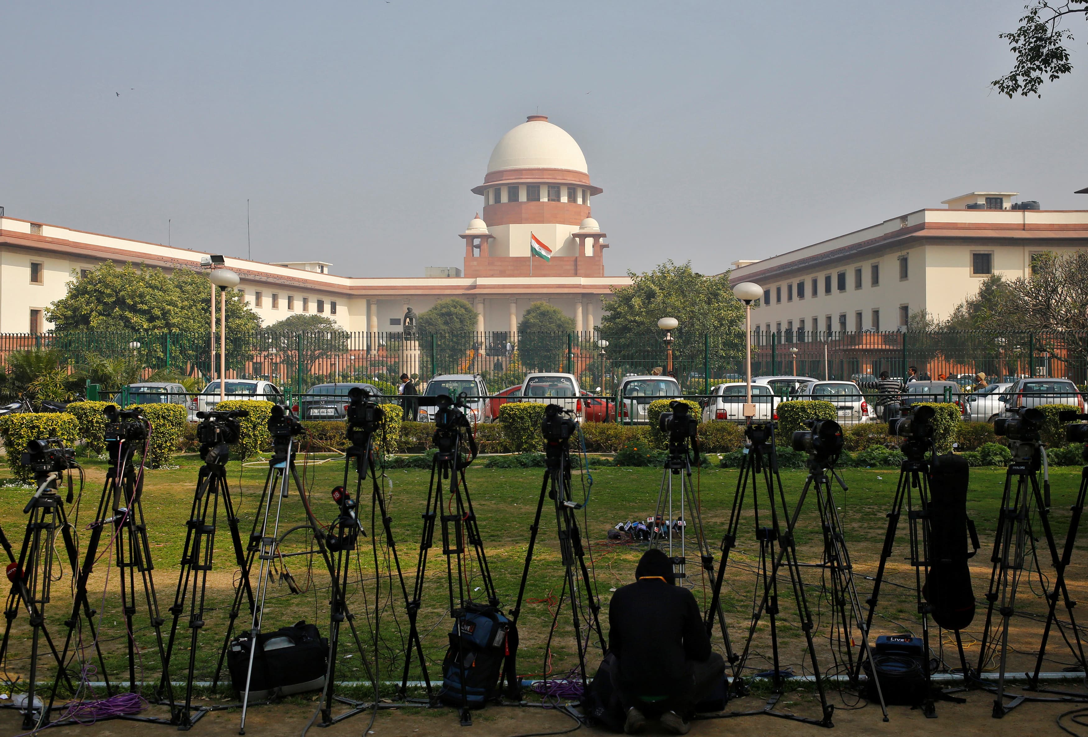 A television journalist sets up his camera inside the premises of the Supreme Court