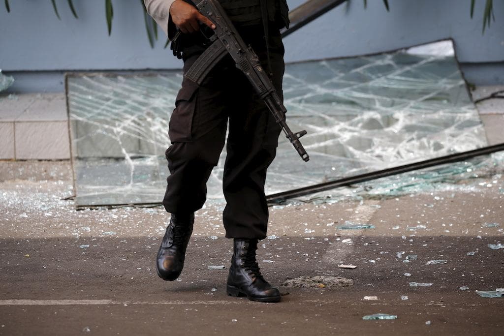 An Indonesian policeman near a broken window from a Starbucks outlet in Jakarta, Jan. 14.