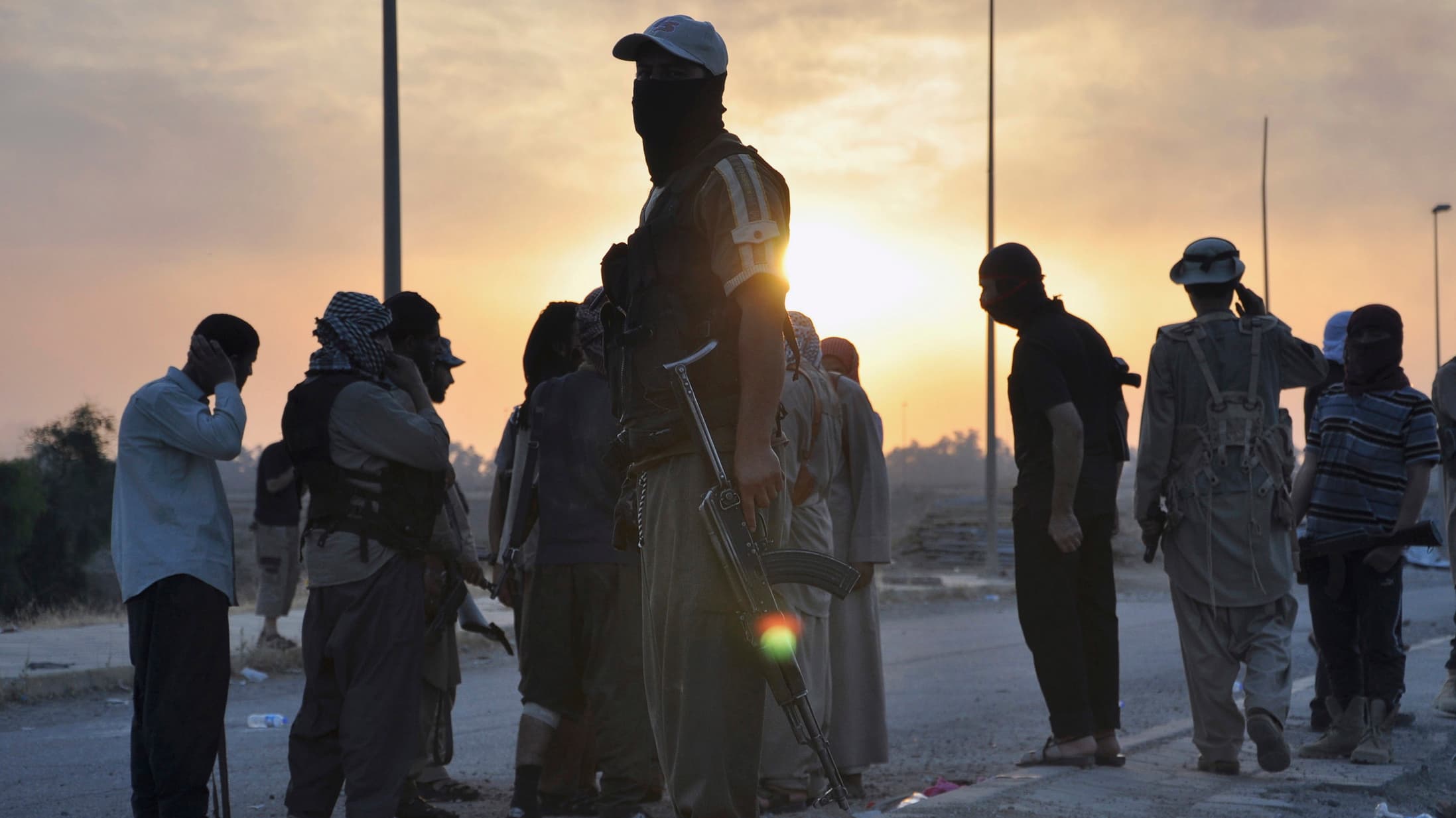 Fighters from the Islamic State of Iraq and Syria (ISIS) stand guard at a checkpoint in the northern Iraq city of Mosul on June 11, 2014. Since Tuesday, black clad ISIL fighters have seized Iraq's second biggest city Mosul and Tikrit, home town of former