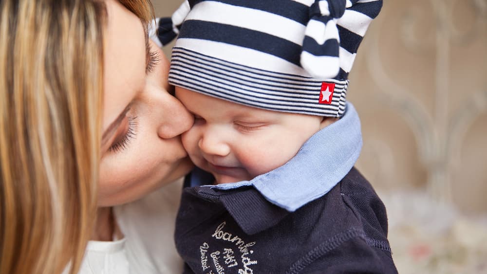 A mother kissing her baby