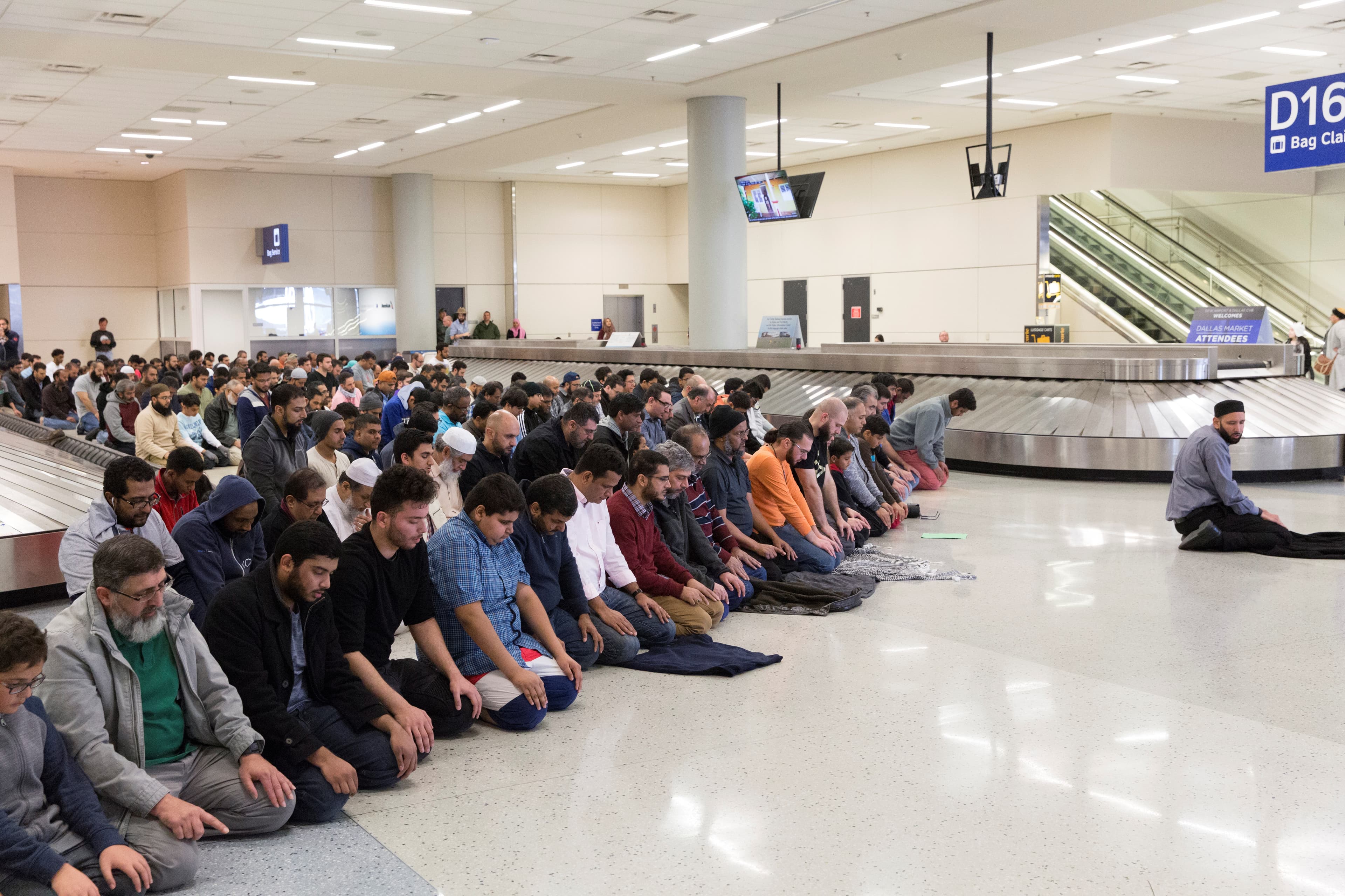 People gather to pray in baggage claim during a protest against the travel ban imposed by President Donald Trump's executive order, at Dallas/Fort Worth International Airport in Dallas, Texas, Jan. 29, 2017.