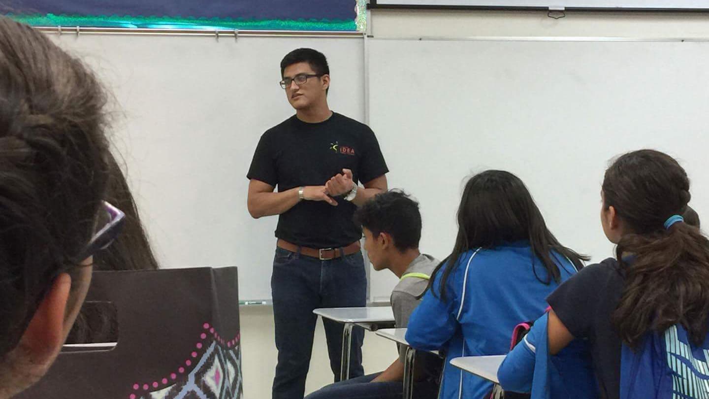View from back of classroom, with backs of children and teacher in front