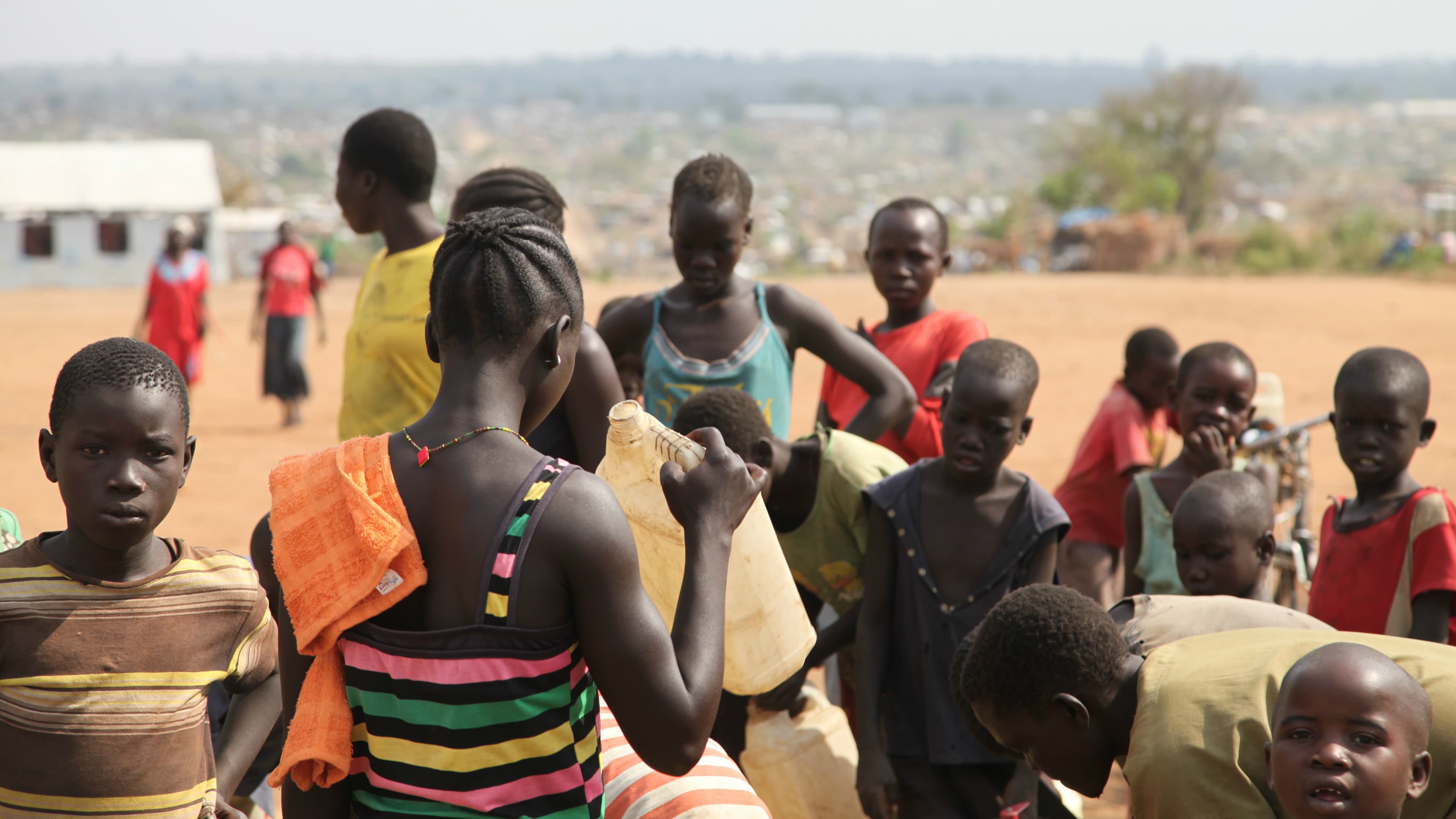 Refugees at Bidi Bidi refugee settlement in Uganda fill jerrycans at the water tank.