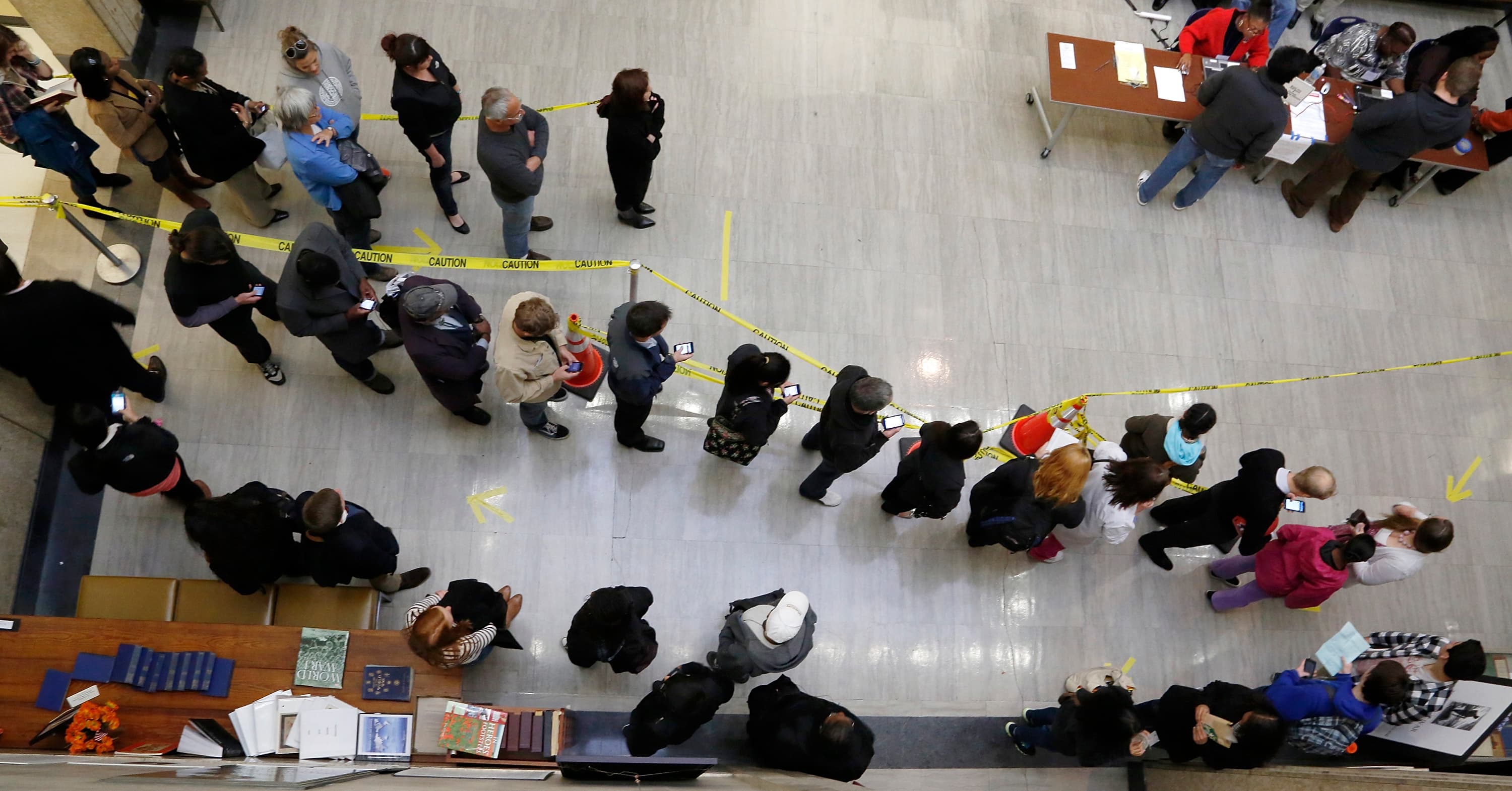 Voters stand in line in a lobby