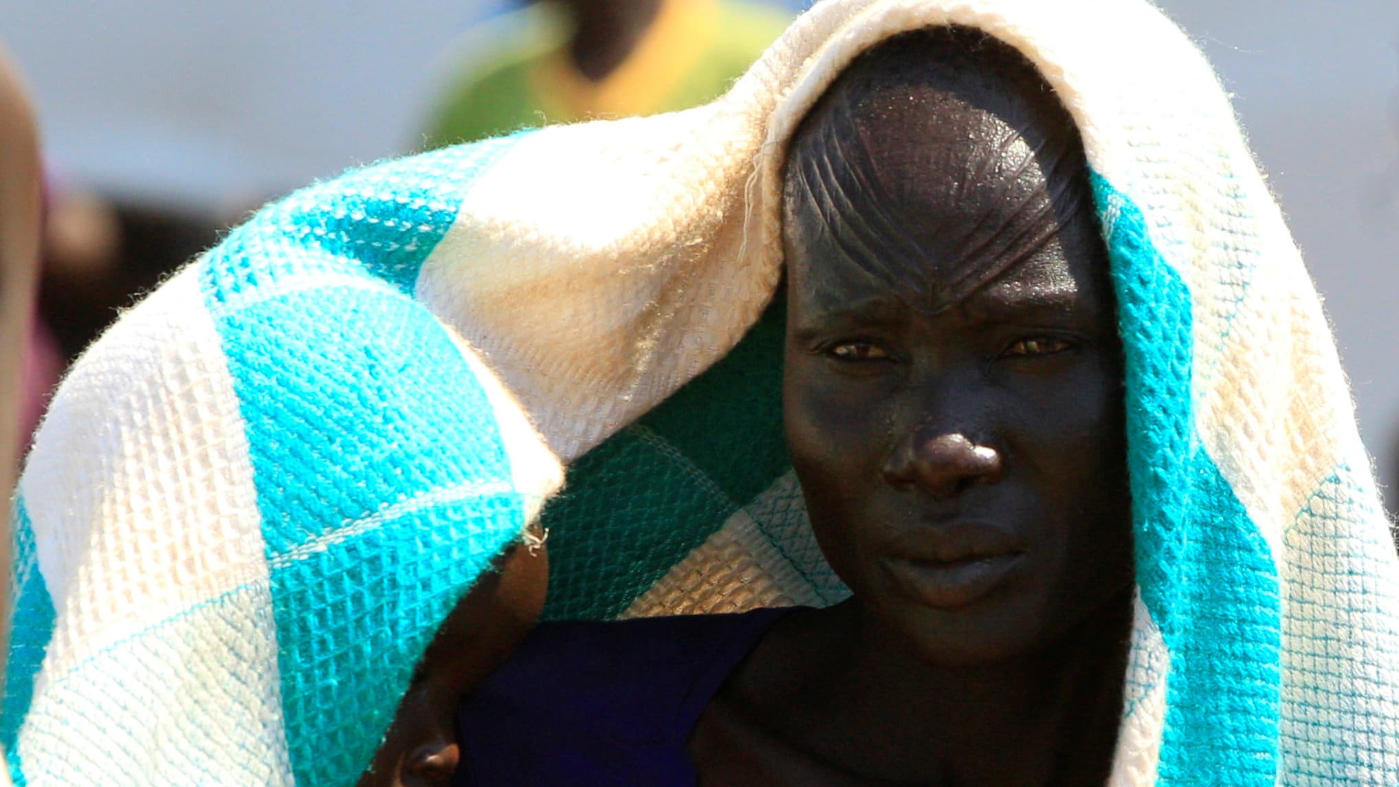 A mother who fled fighting in South Sudan carries her child on arrival at Bidi Bidi refugee resettlement camp near the border in Yumbe district, northern Uganda, Dec. 7, 2016.