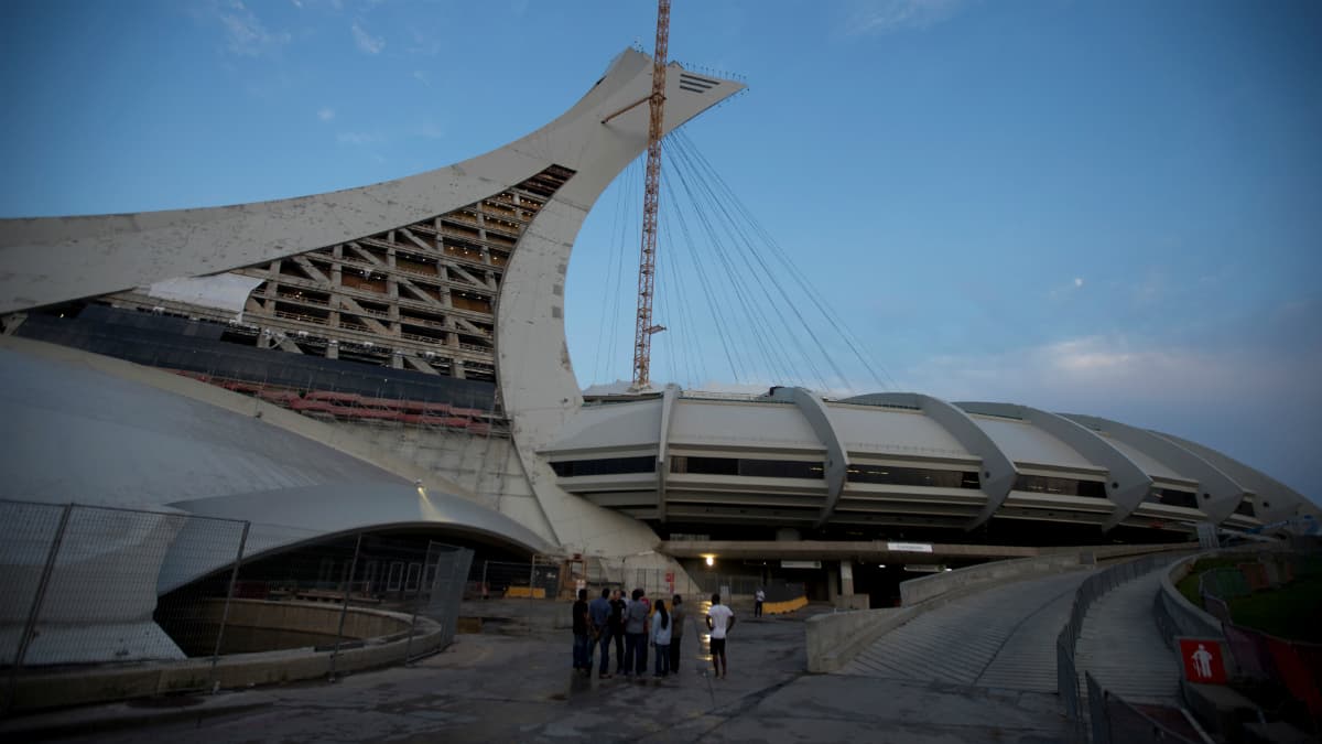 A security guard speaks to a group of men at the Olympic Stadium, which is being used for temporary housing for asylum seekers in Montreal, Quebec, Canada, August 2, 2017.