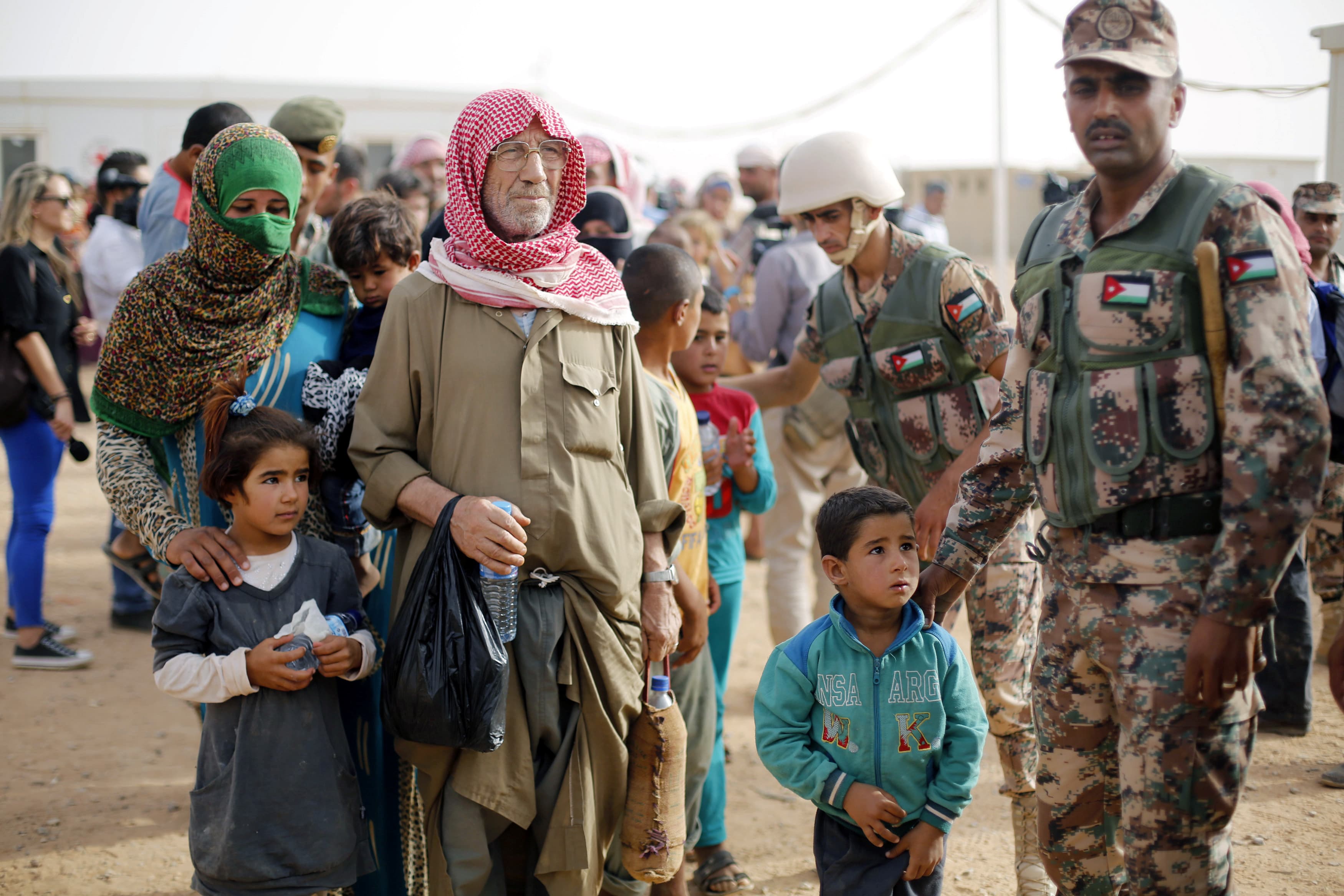 Syrian refugees wait to board a Jordanian army vehicle after crossing into Jordanian territory with their families, in Al Rukban border area, near the northeastern Jordanian border with Syria and Iraq, Sept. 10, 2015.