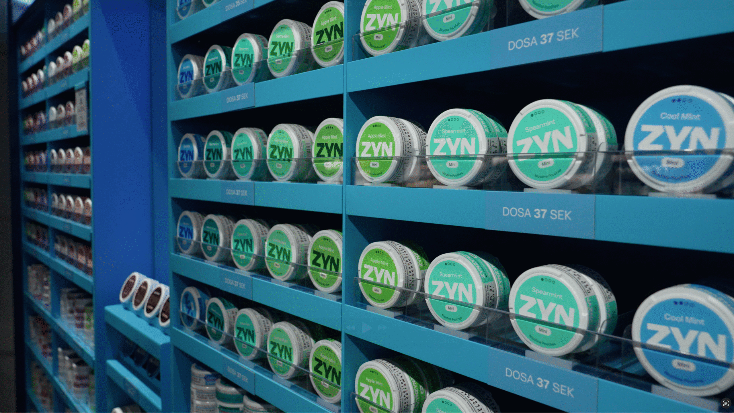 Shelves stocked with various flavors of Zyn nicotine pouches, including Apple Mint, Spearmint, and Cool Mint, priced at 37 SEK, displayed in a blue retail setting.