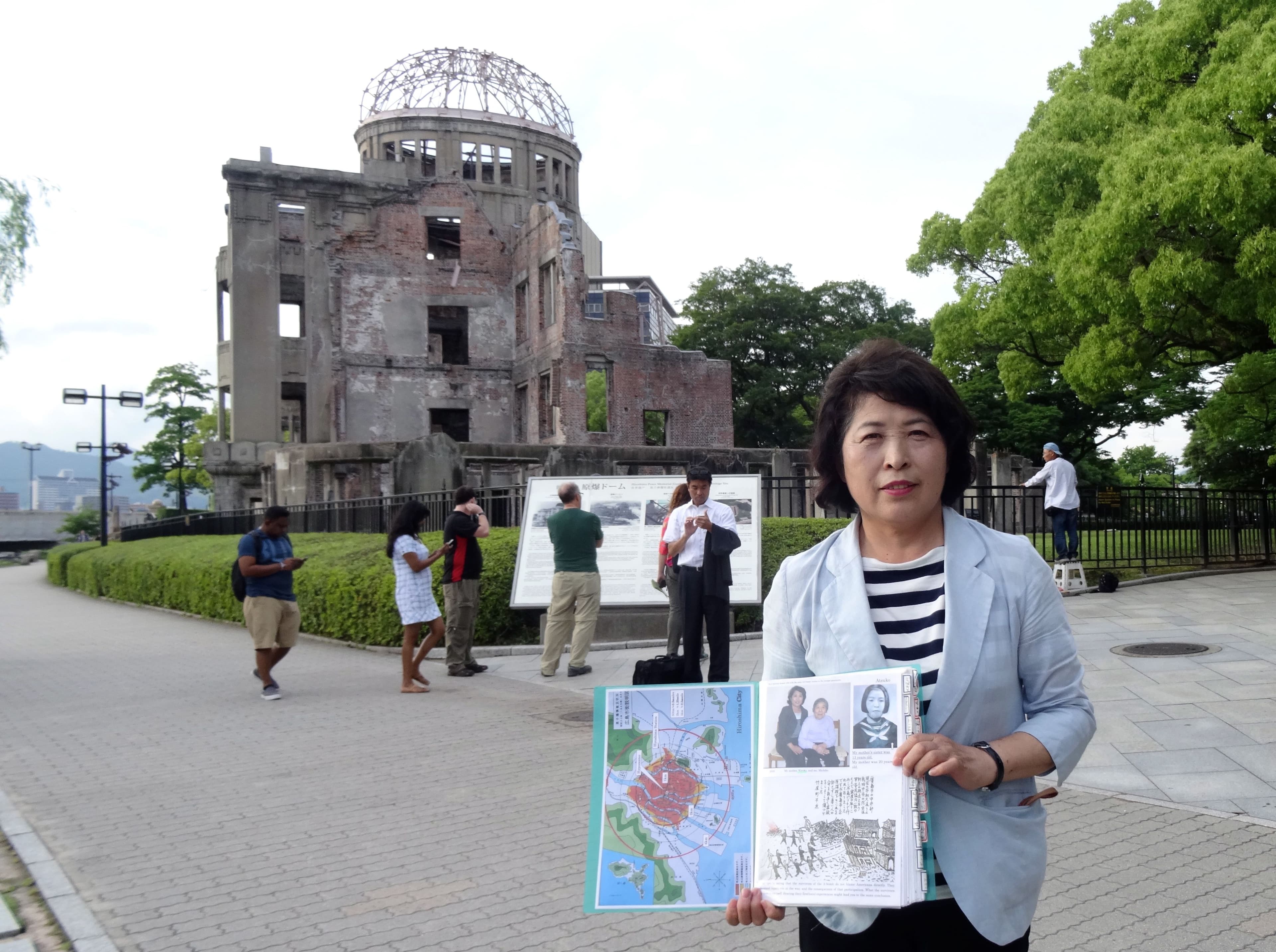 Hiroshima guide and 'memory keeper' Michiko Yamaoka holds a folder containing photos of her mother, who survived the blast, and her aunt, who died.