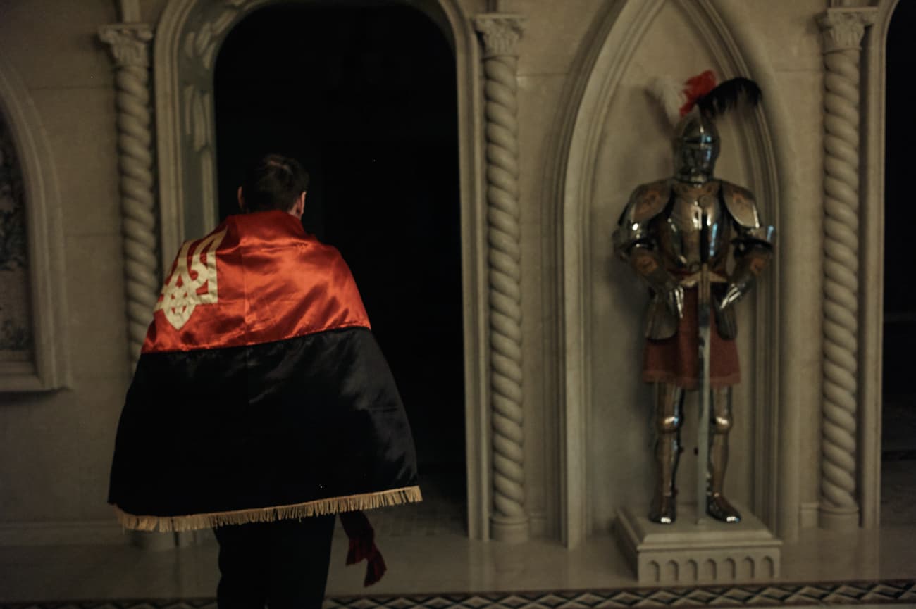 Petro Oliynyk with a Ukrainian emblem embroidered flag draped around his shoulders.