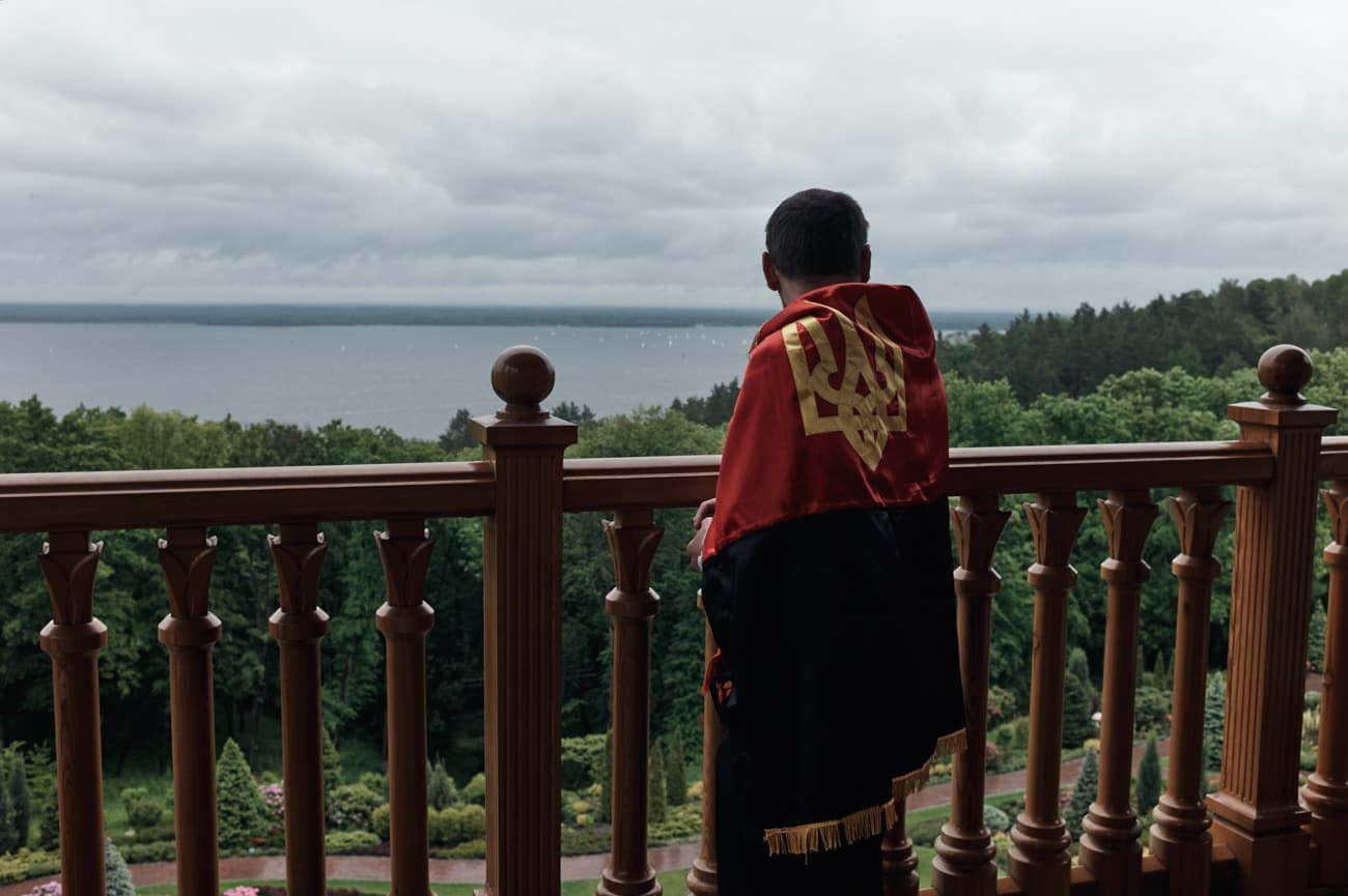 Petro Oliynyk with a the Ukrainian emblem embroidered flag draped around his shoulders.