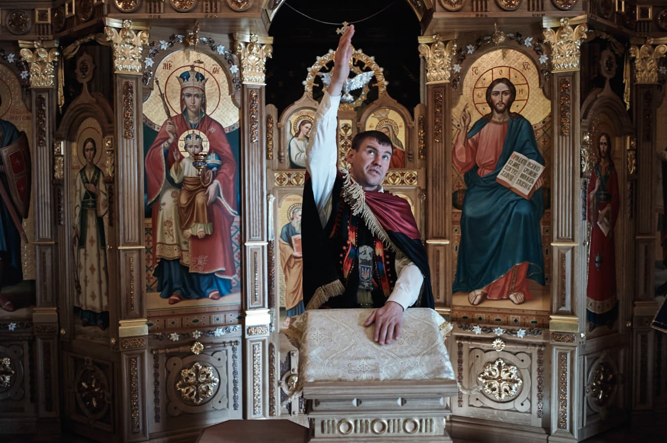 Petro Oliynyk, 34, a grocery salesman from Lviv has, came to Mezhyhirya from Maidan where he participated in the revolution and has remained there ever since guarding/protecting it from looters. Here he stands in the private chapel inside the main house.