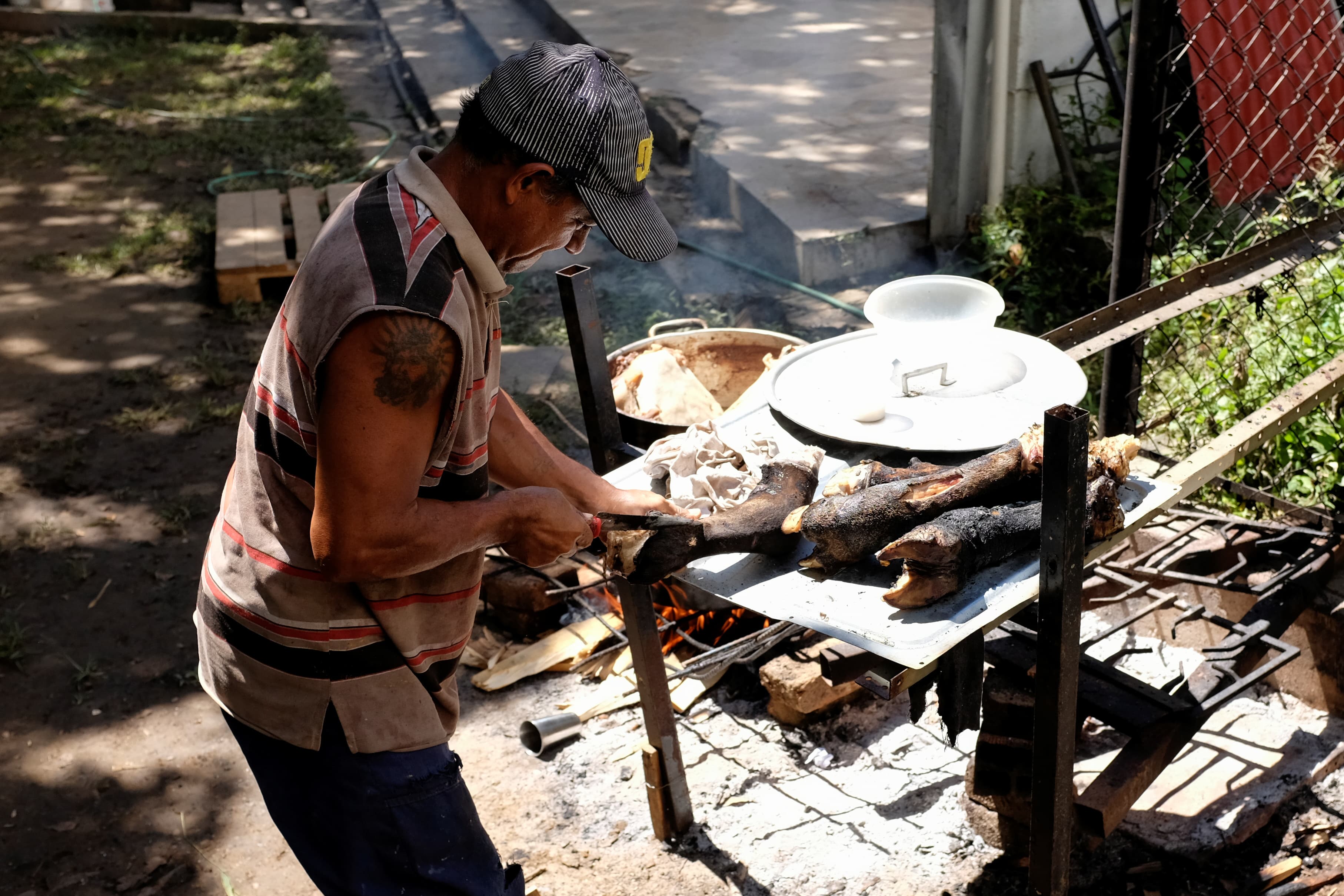 A man standing over a grill